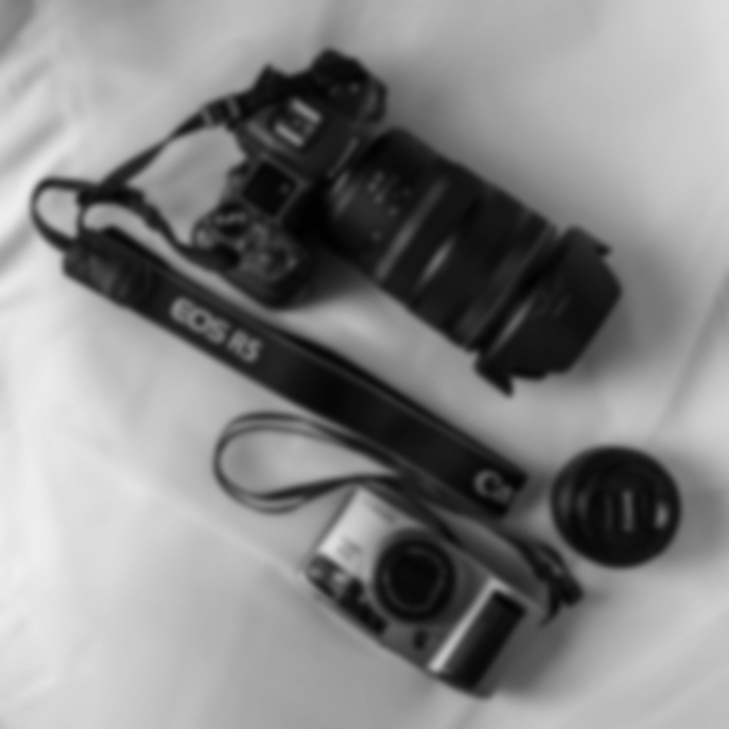 Blurry black and white photograph of camera equipment on a white background, photographed by Worcestershire photographer EvieSJPhotography.