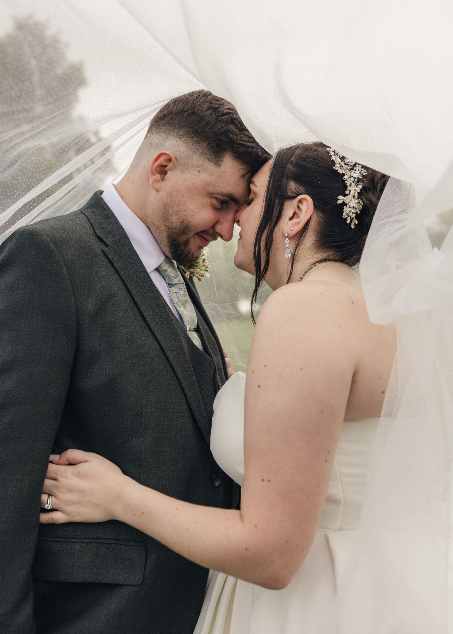 Cortney and Dan sharing an intimate moment during wedding day portraits under the bride's veil.
