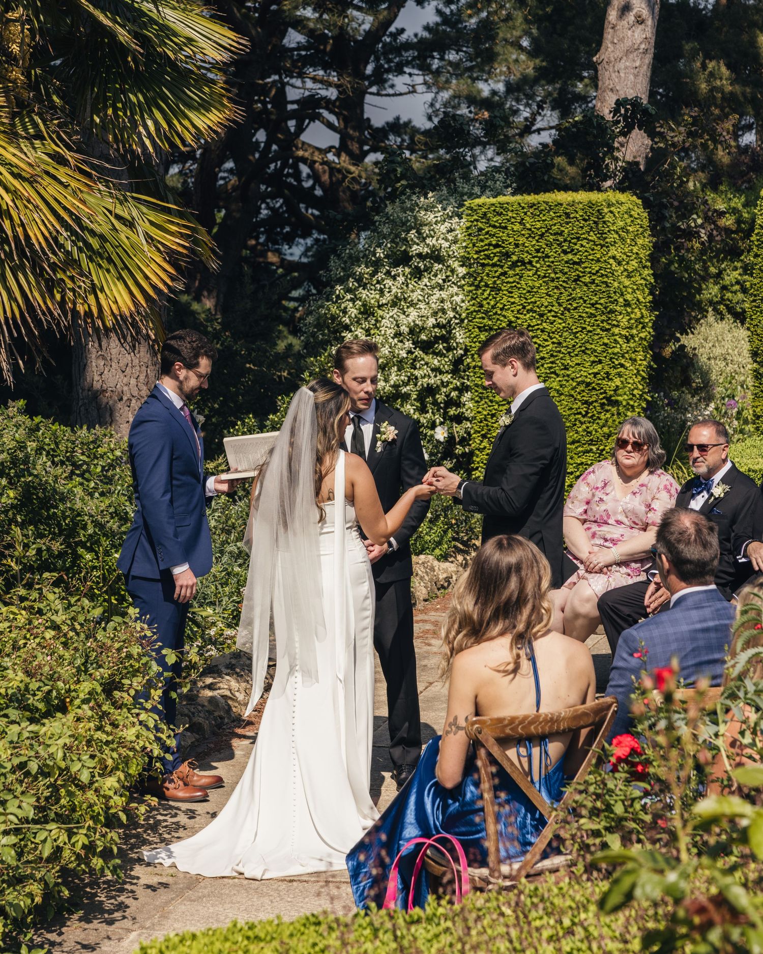 Mid-ceremony, a bride and groom about to get married as their best man hands over the rings, captured by EvieSJPhotography.