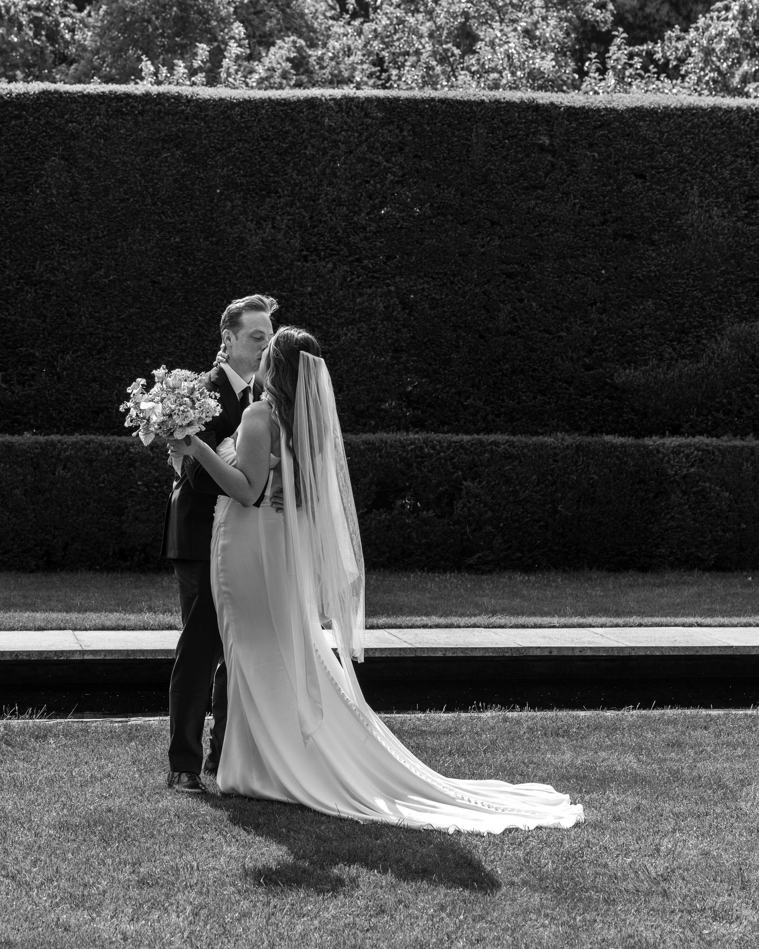 Bride and groom sharing a romantic moment on their wedding day, captured in a relaxed documentary style by EvieSJPhotography.