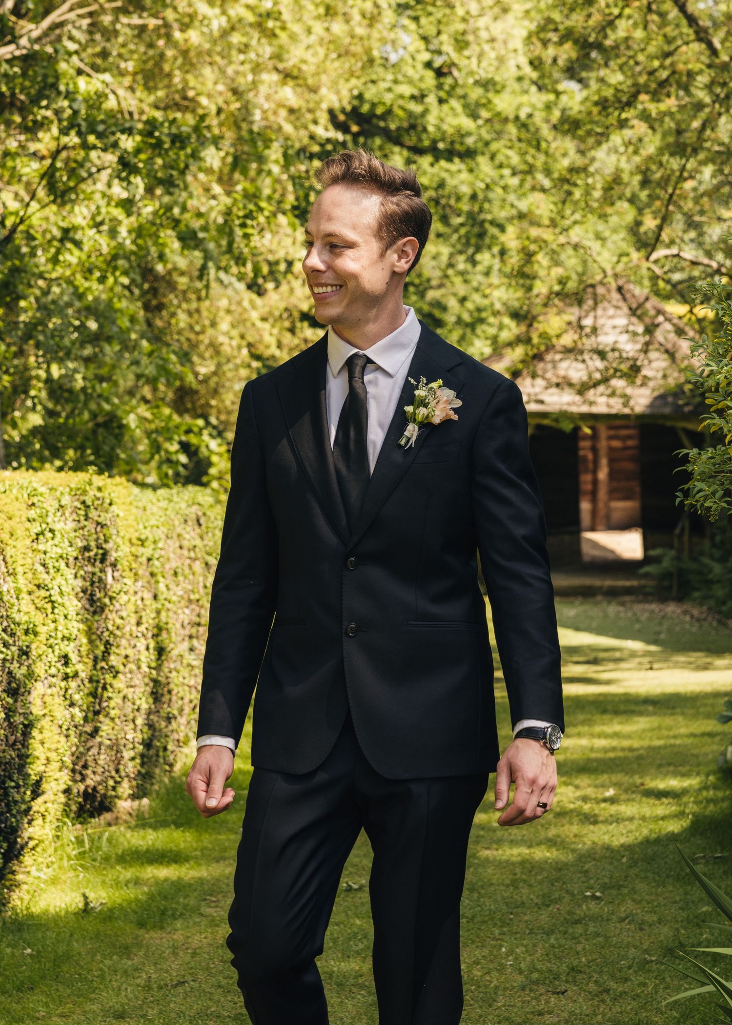 Groom smiling during his solo photoshoot on his wedding day, captured by EvieSJPhotography.