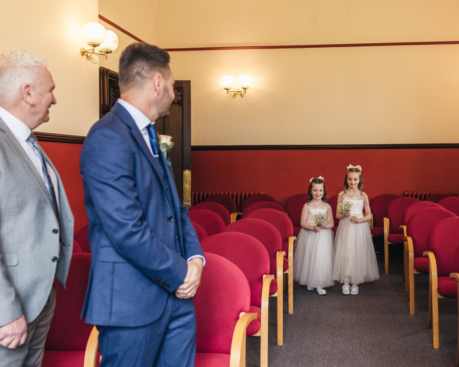 Bridesmaids walking down the aisle to meet their father, captured by EvieSJPhotography.