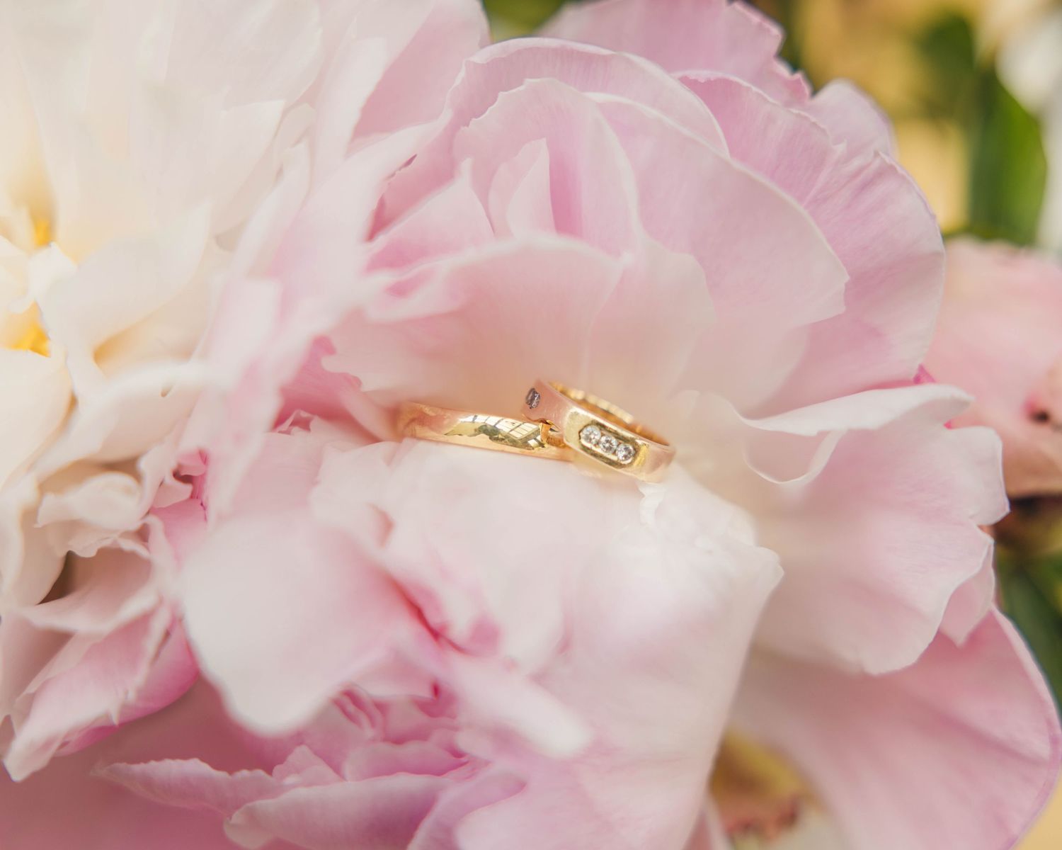 Two wedding rings placed inside a flower, captured by EvieSJPhotography.