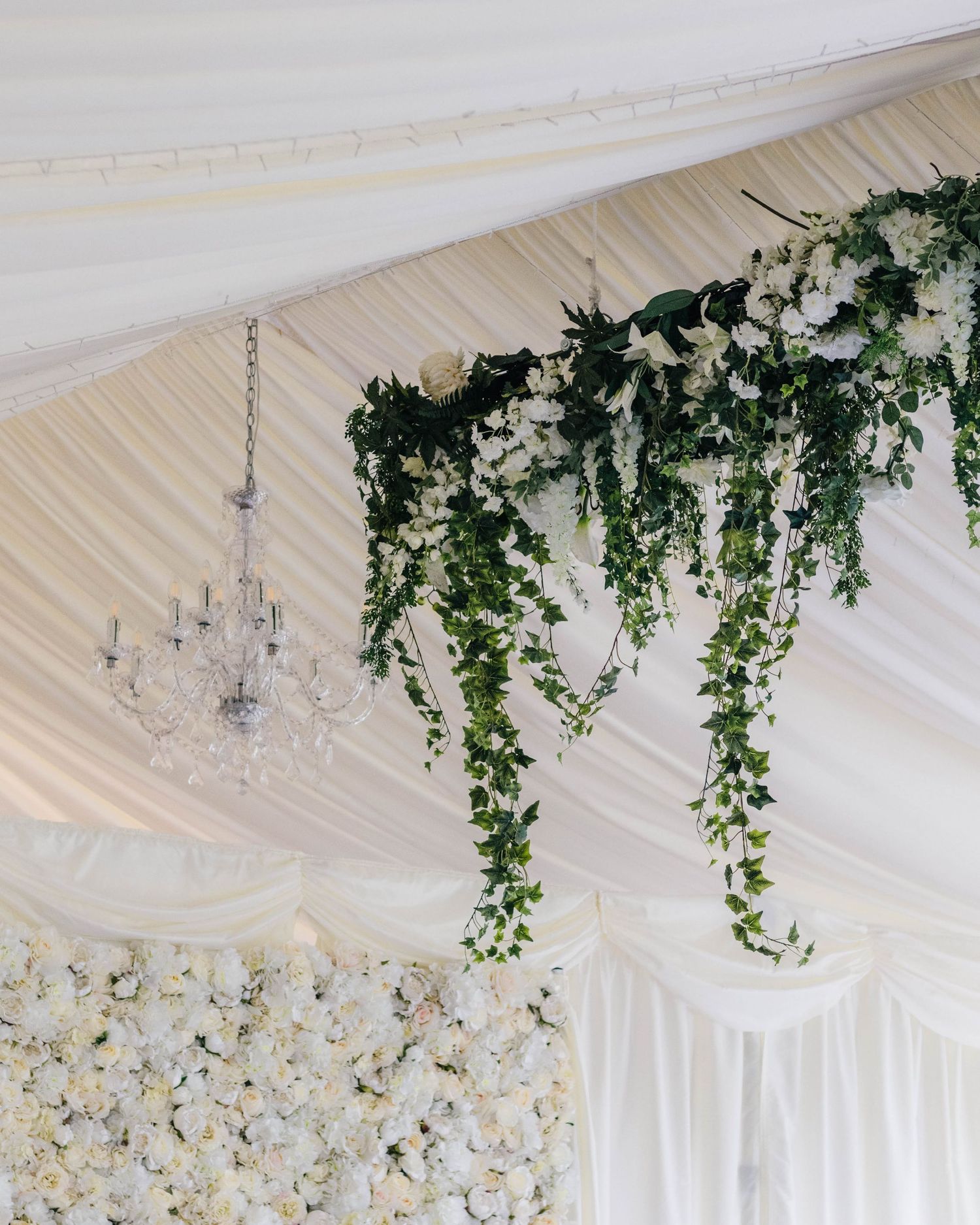 Wedding reception draping decorations with green ivy flowing from ceiling. Captured in a natural, lifestyle way by EvieSJPhotography.