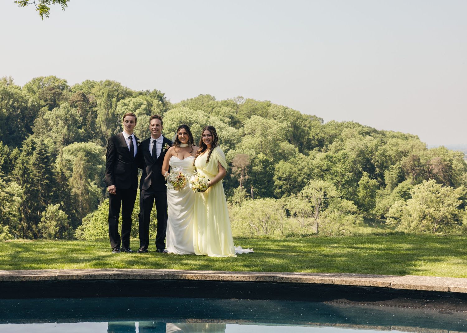 A bride and groom with their maid of honour and best man during a group photoshoot, captured by EvieSJPhotography.