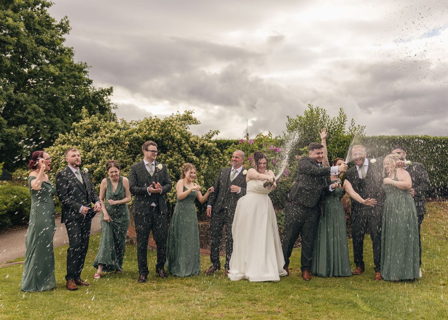 Cortney and Dan spraying champagne with their bridal party on their wedding day at Windmill Village Hotel.