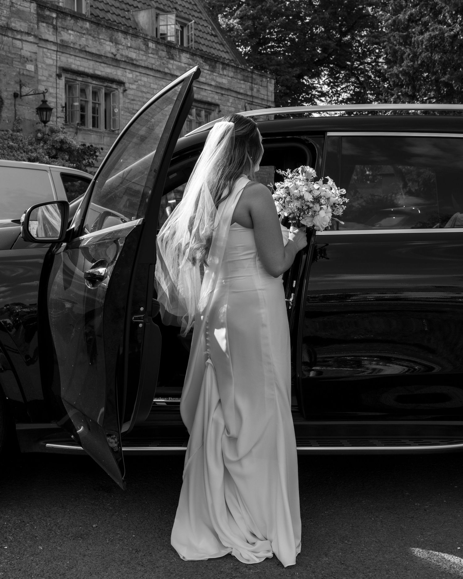 Bride walking out of a cottage to go to her wedding venue.