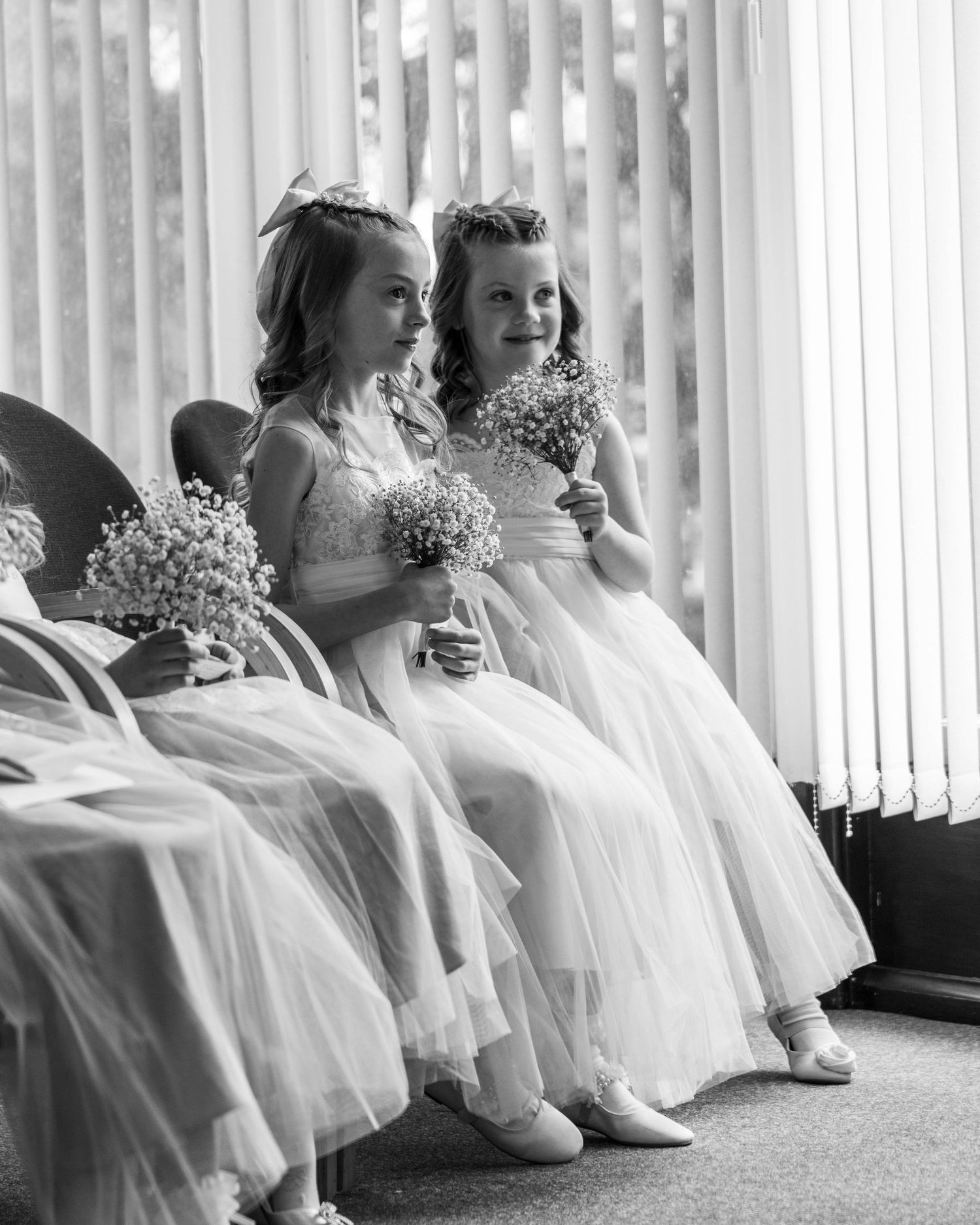Two daughters smiling whilst watching their parents getting married, captured by EvieSJPhotography.