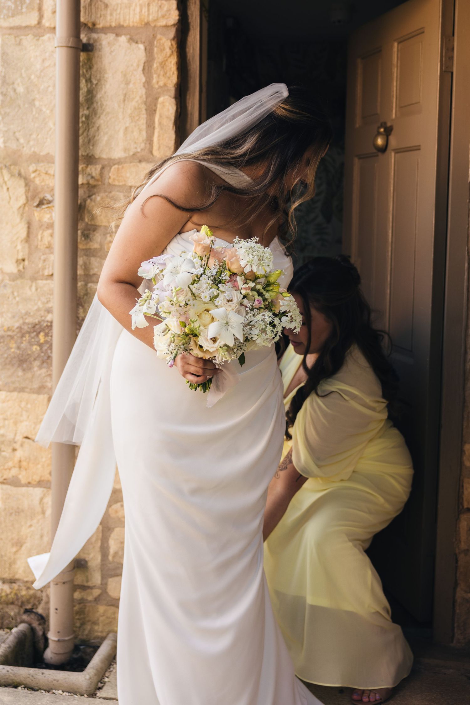 Bride walking out of a cottage to go to her wedding venue.