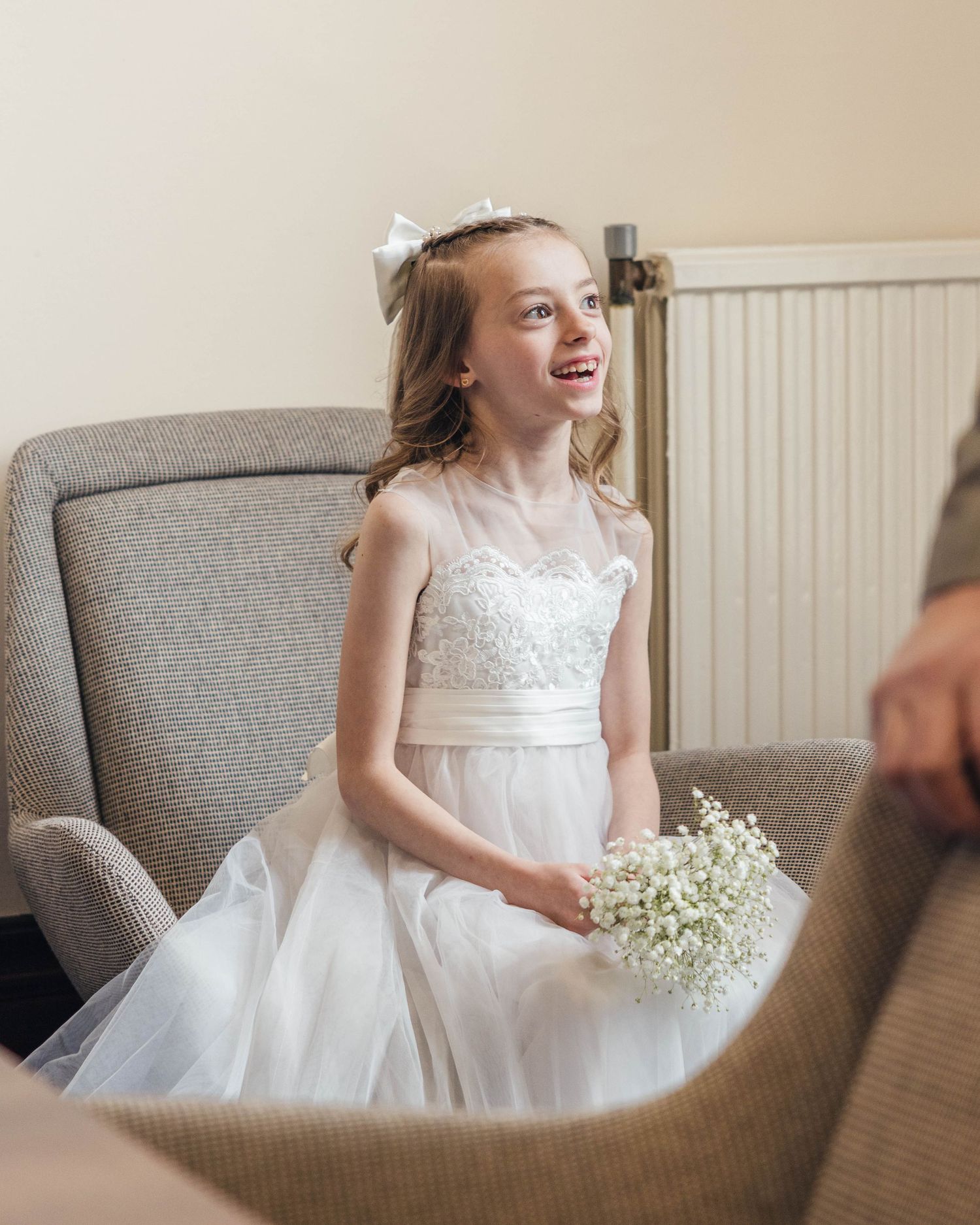 A bridesmaid smiling and laughing before the wedding ceremony, captured by EvieSJPhotography.