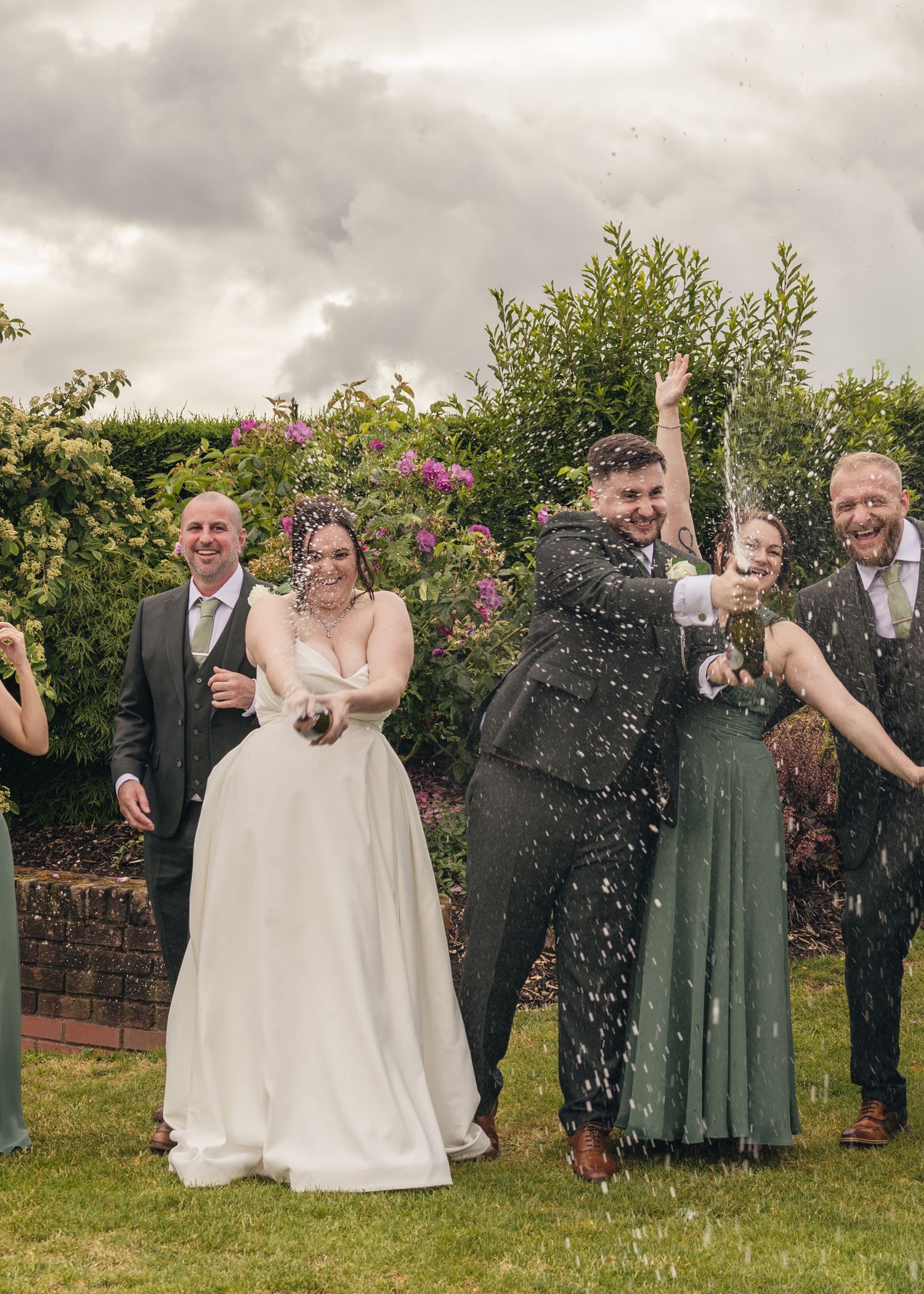 Cortney and Dan spraying champagne with their bridal party on their wedding day at Windmill Village Hotel.