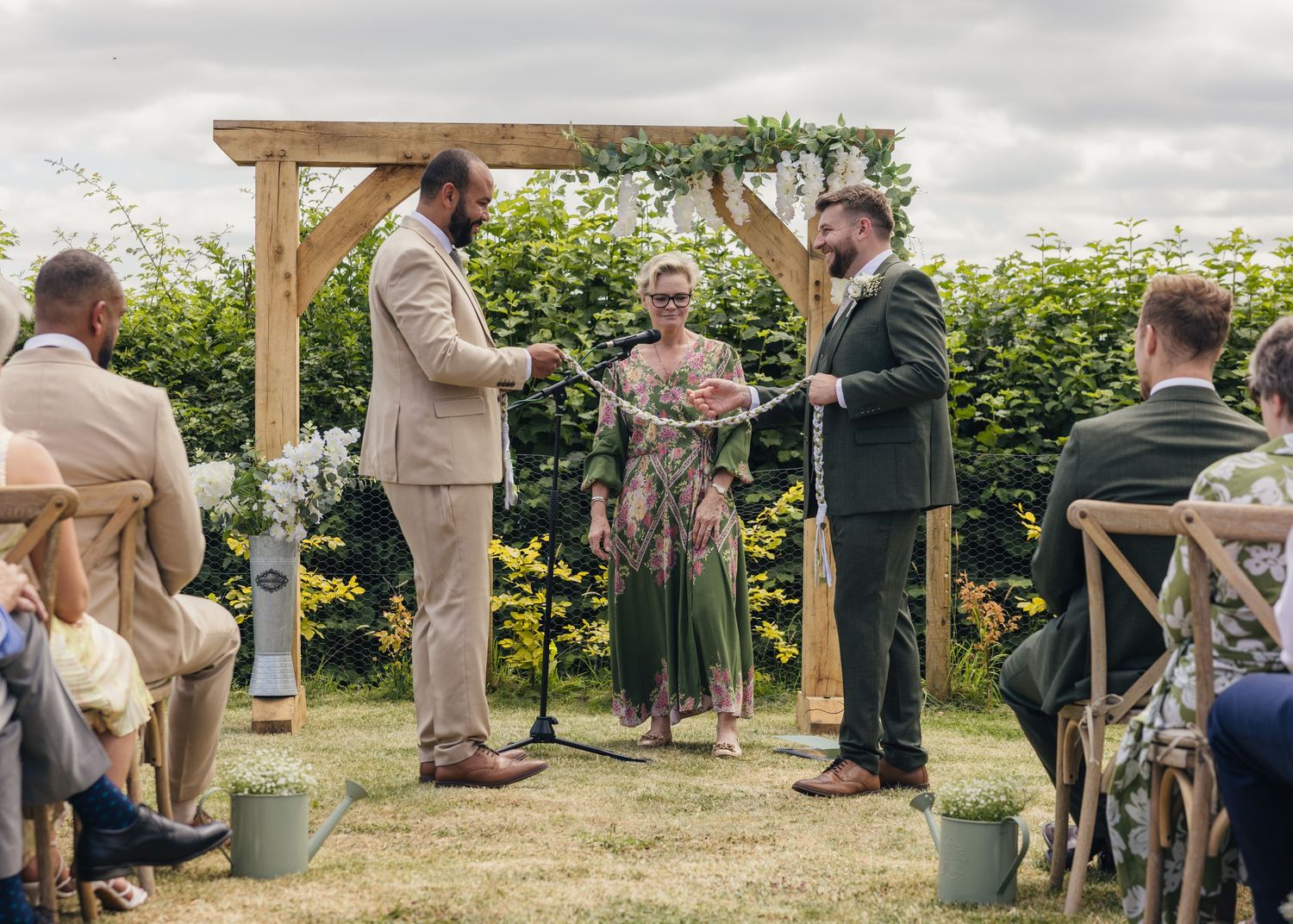 Aaron and Jack during their handfasting ceremony during their outdoor ceremony at Rock Village Hall.