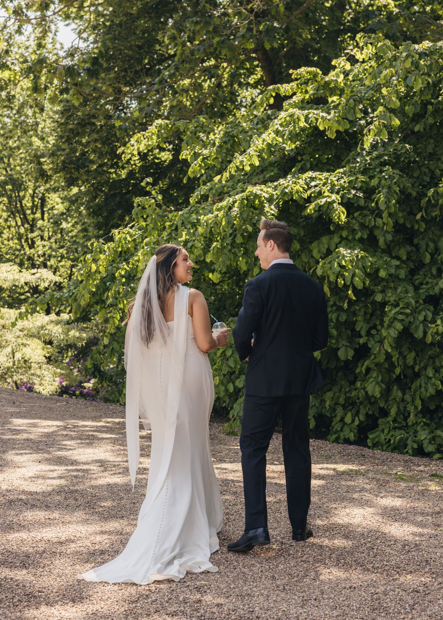 Bride and groom sharing a romantic moment on their wedding day, captured in a relaxed documentary style by EvieSJPhotography.