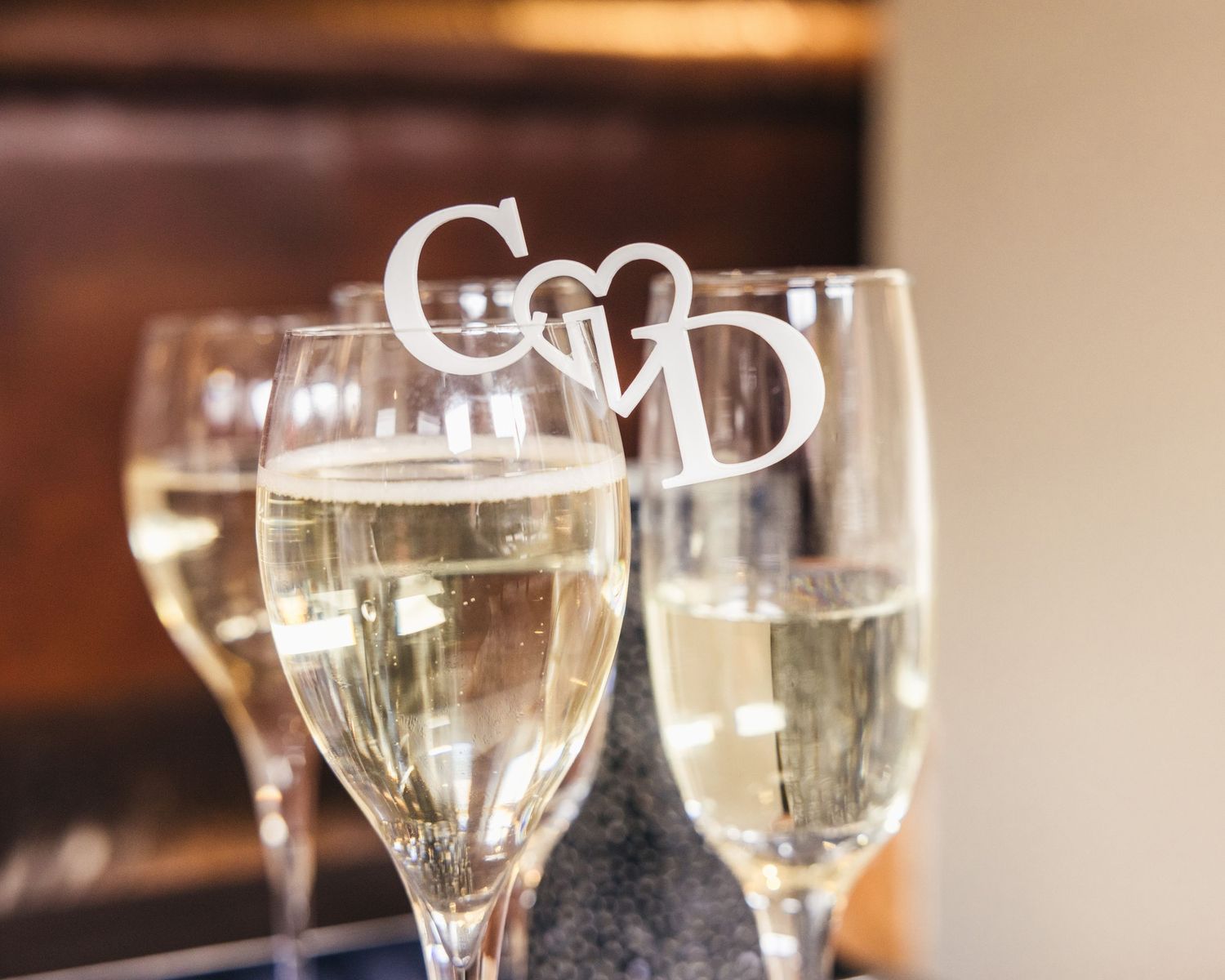 Champagne glasses decorated with personalised initials for Cortney and Dan's wedding celebration.