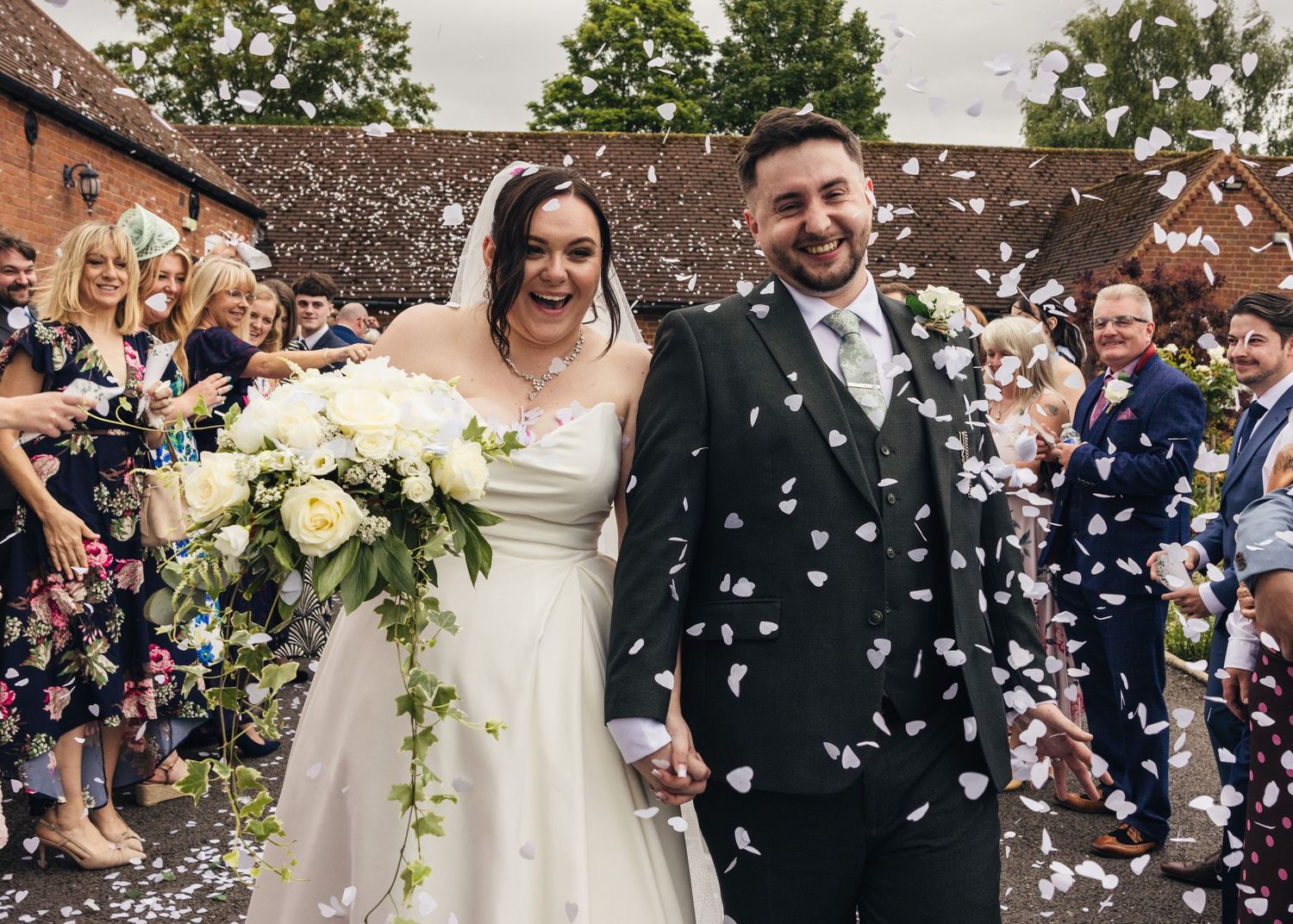 Cortney and Dan smiling together during their confetti throw on their wedding day at Windmill Village Hotel.