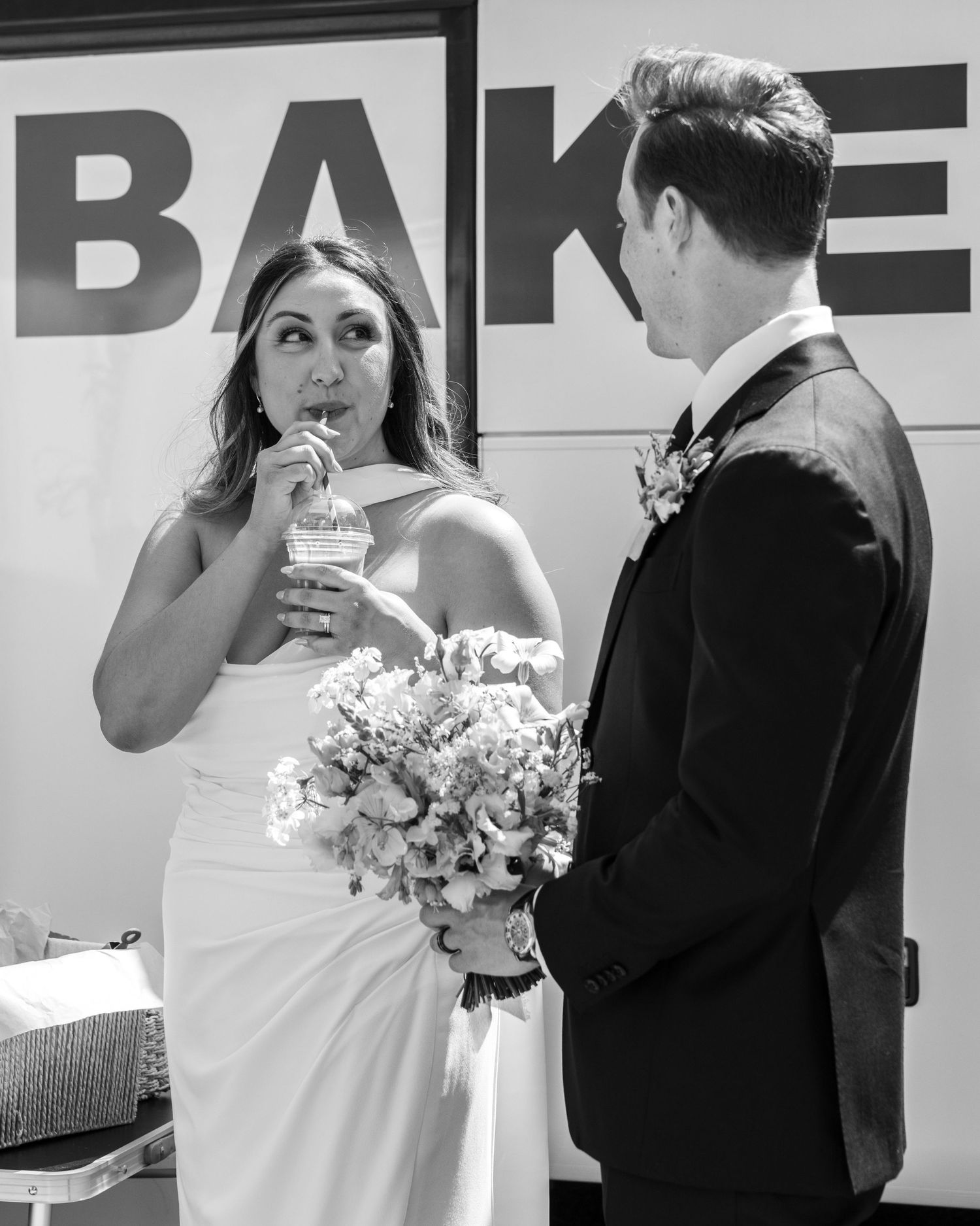 A bride and groom enjoying their refreshing iced coffee during a hot wedding day, captured by EvieSJPhotography.
