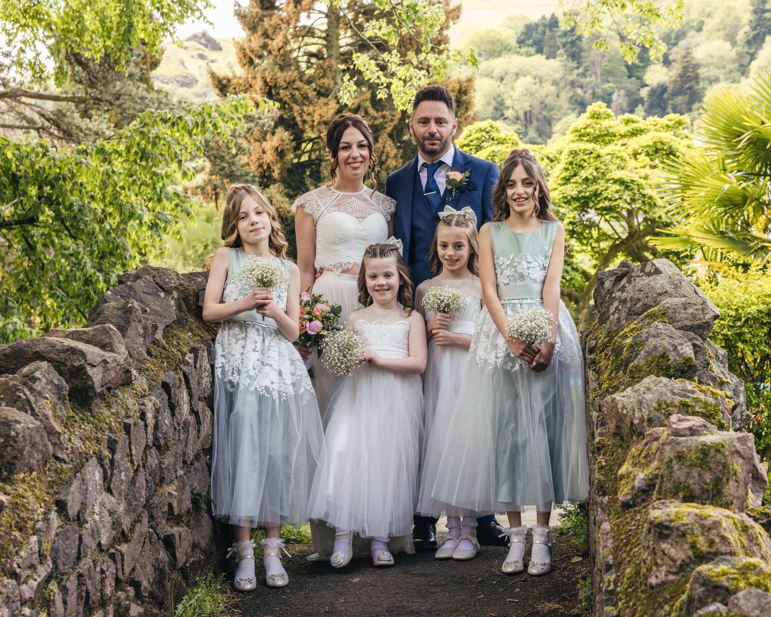 A bride, groom and their daughters having a group photo after the ceremony, captured by EvieSJPhotography.