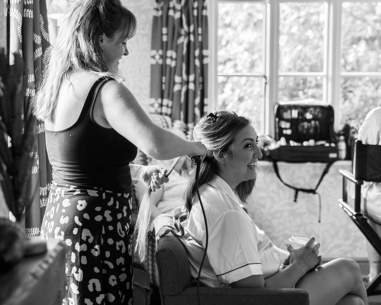 A bride having her hair done during morning prep on her wedding day, captured by EvieSJPhotography.