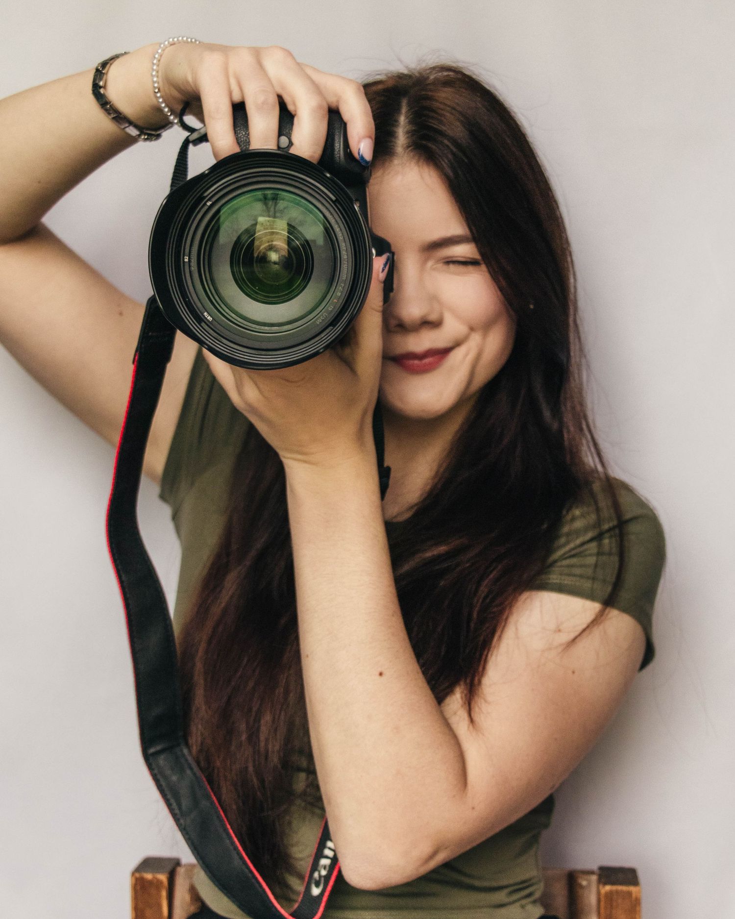An image of a woman holding up a camera, captured by EvieSJPhotography.