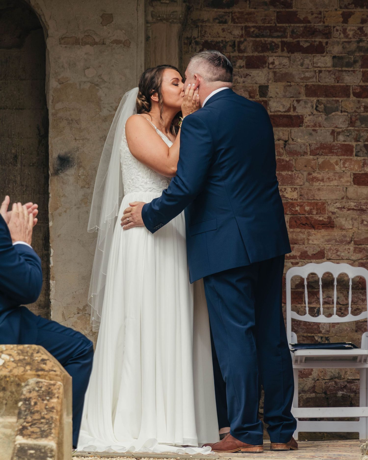 Bride and groom sharing a romantic kiss on their wedding day, captured in a relaxed documentary style by EvieSJPhotography.