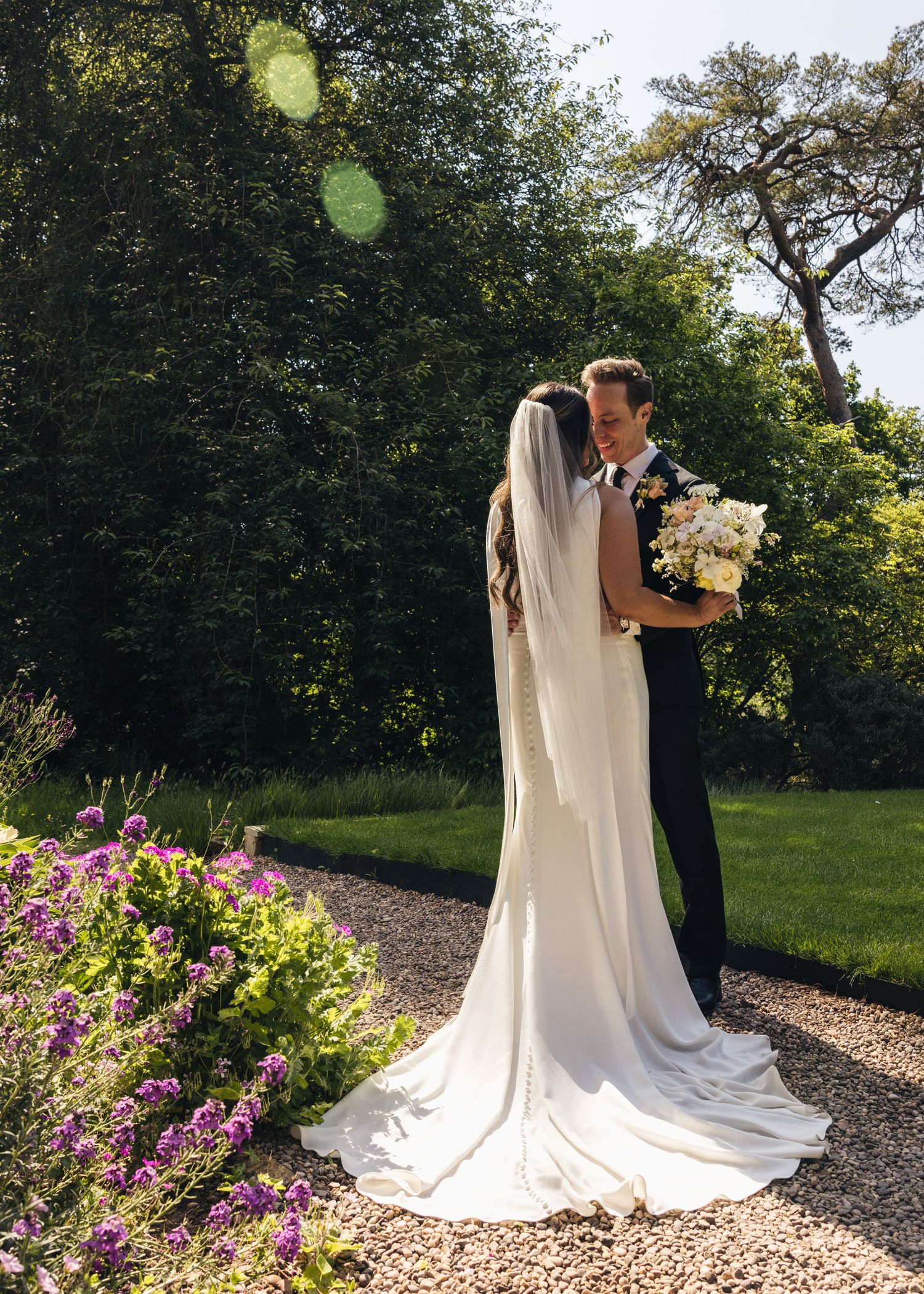 Bride and groom sharing a romantic moment on their wedding day, captured in a relaxed documentary style by EvieSJPhotography.