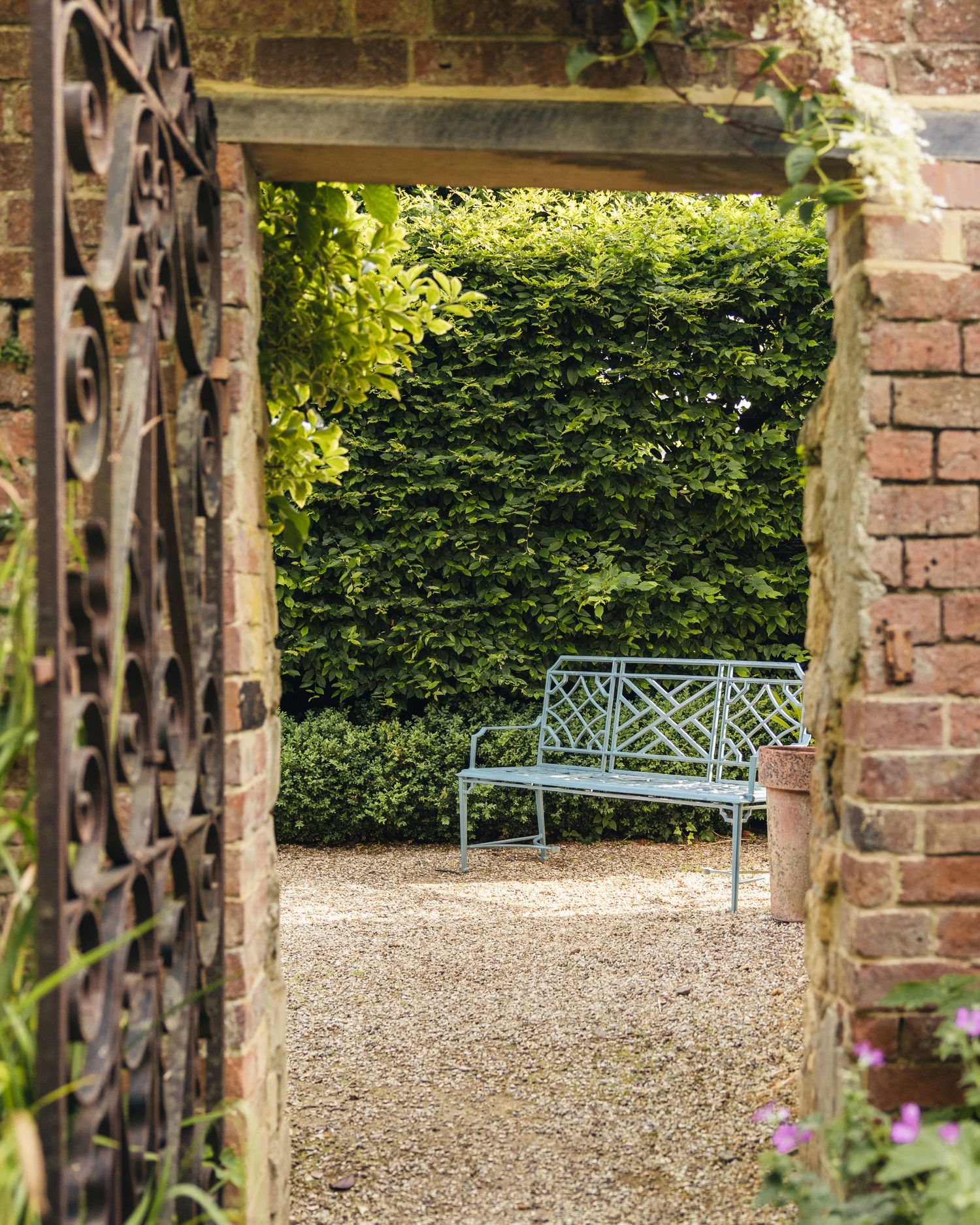 Bench in a small garden at Manor House Hotel in the Cotswolds, captured by EVieSJPhotography.