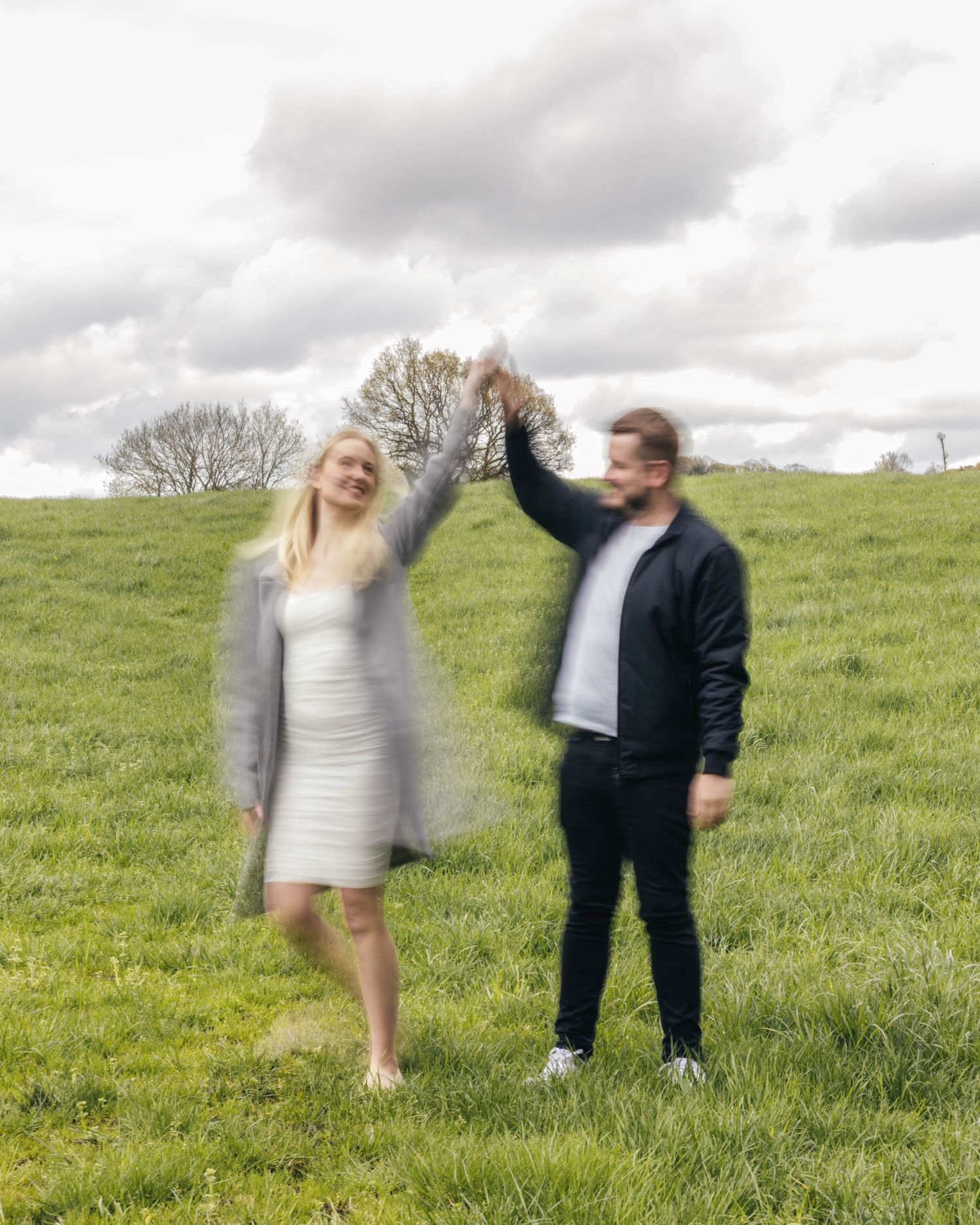 Natural engagement photoshoot of a couple in a field by EvieSJPhotography.