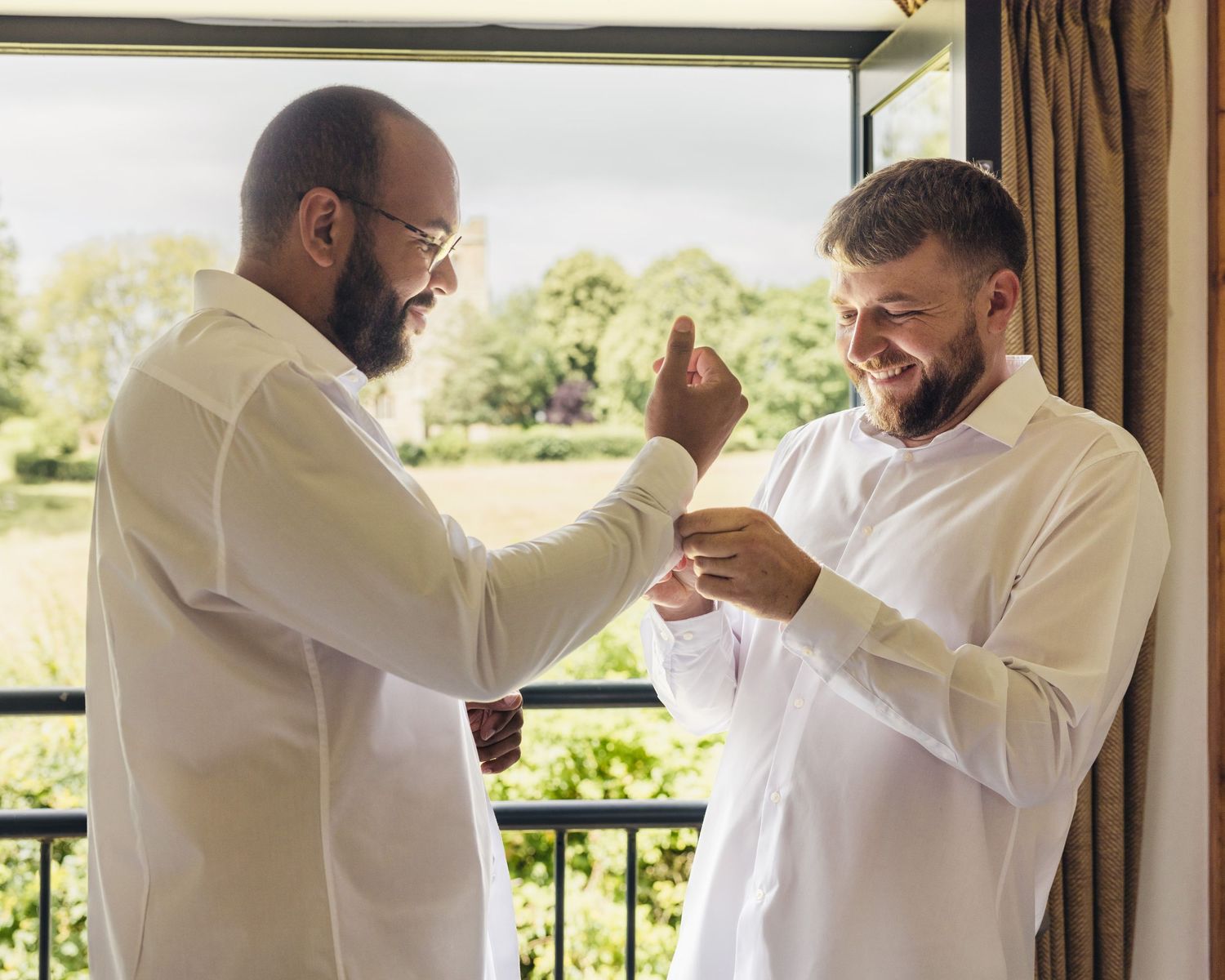 Jack helping Aaron with his cufflinks during morning prep at Rock Village Hall ahead of their wedding ceremony.
