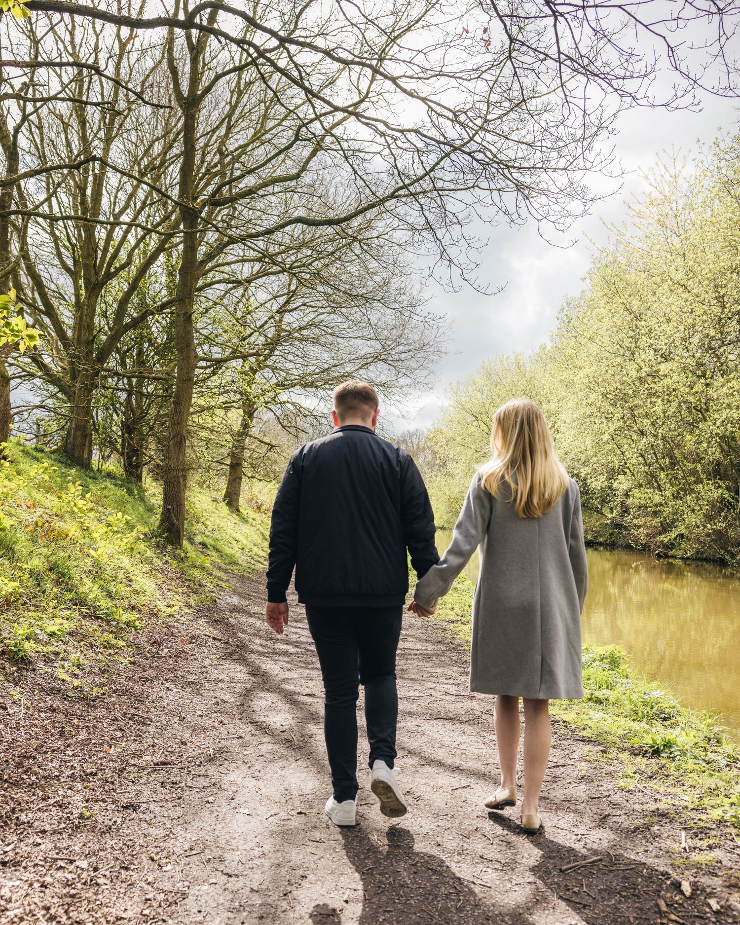 Natural engagement photoshoot of a couple by a canal captured by EvieSJPhotography.