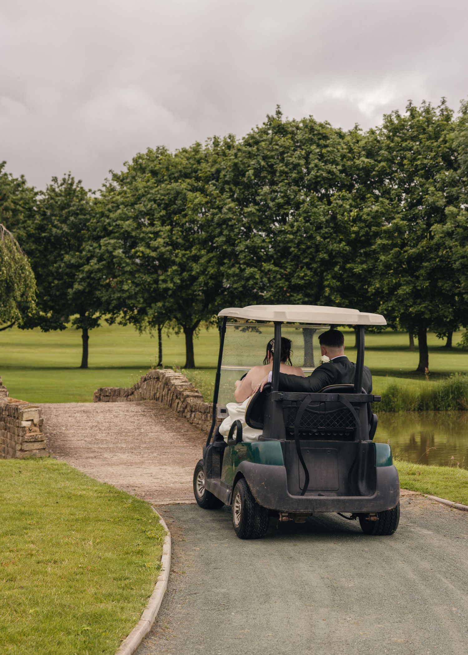 Cortney and Dan riding around in a golf cart on their wedding day at Windmill Village Hotel.