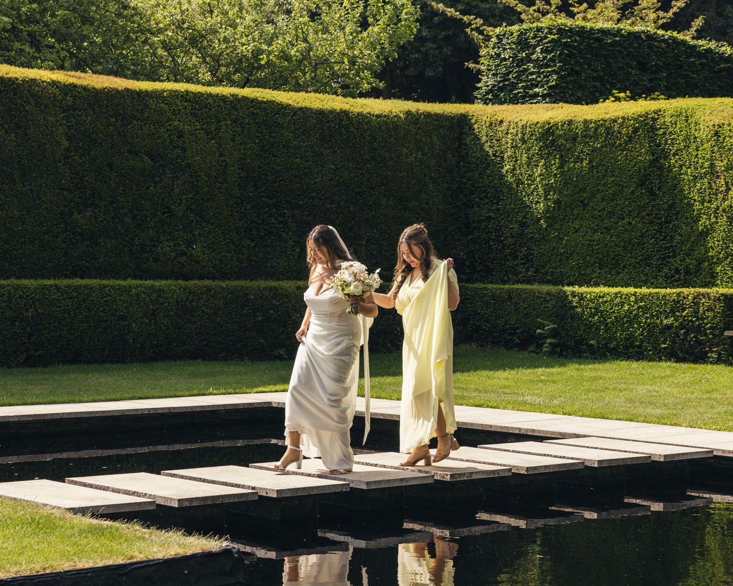 Bride and her bridesmaid walking to her first look.