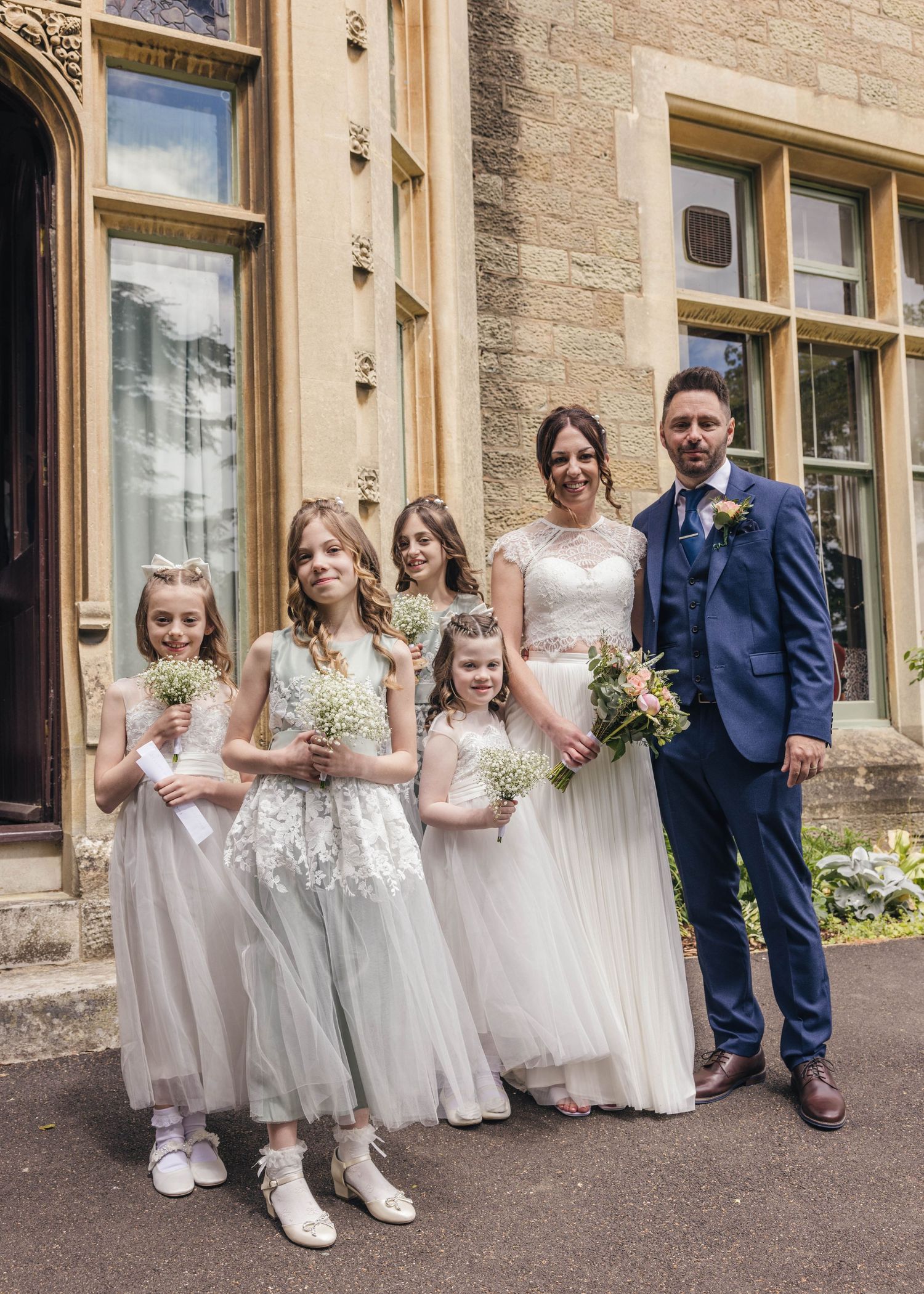 Bride, groom and their daughters having a group photo, captured by EvieSJPhotography.