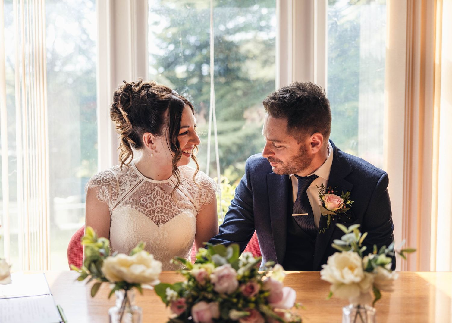 A bride and groom sharing a romantic moment during their ceremony, captured by EvieSJPhotography.