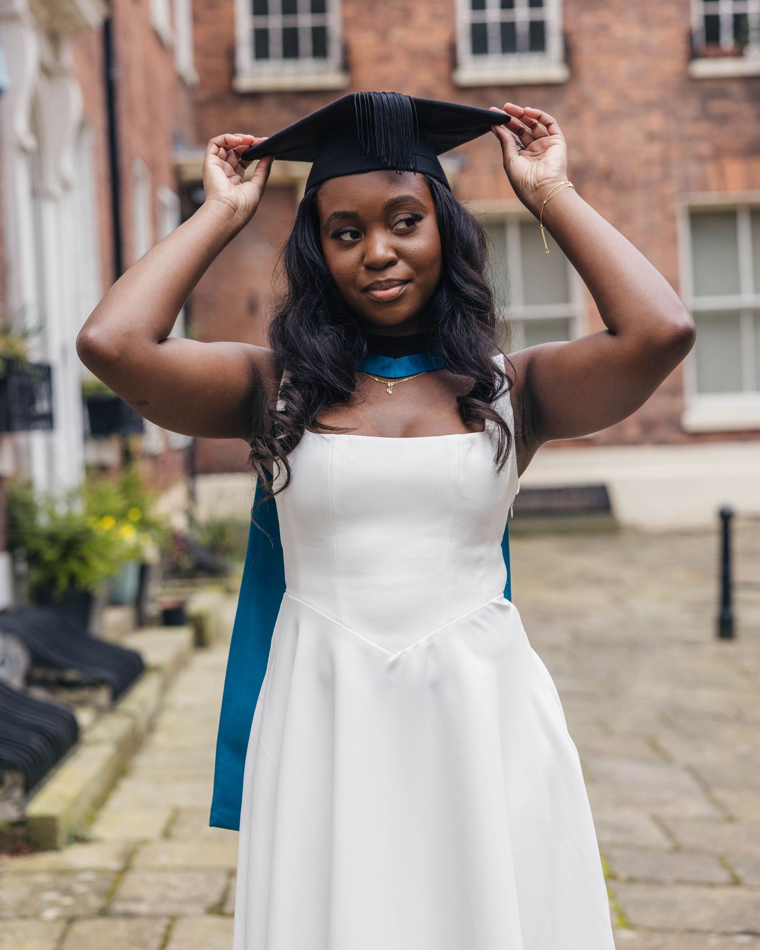 University graduate smiling in cap and gown during a graduation photoshoot by EvieSJPhotography.