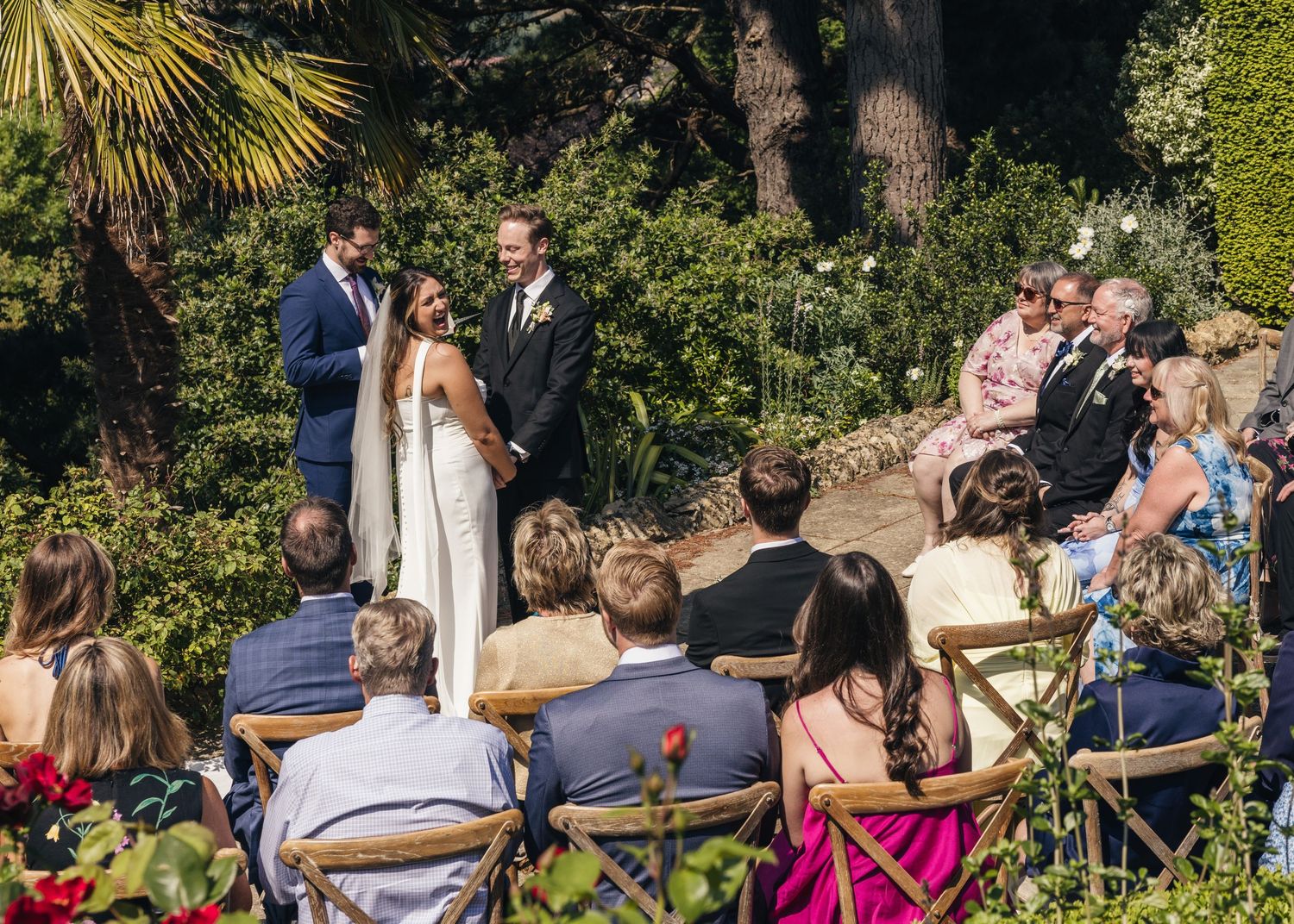 A bride looking back at her family and friends smiling during the wedding ceremony.
