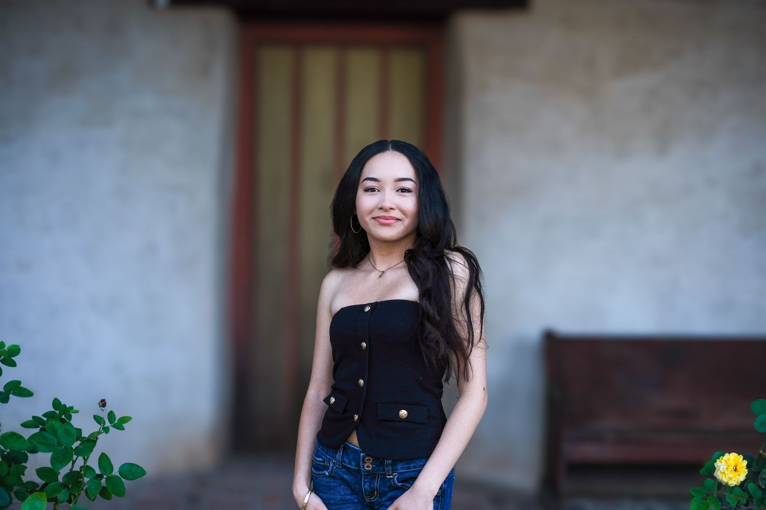 A series of outdoor portrait photographs showing someone in a black top and blue jeans posing against a rustic wall.