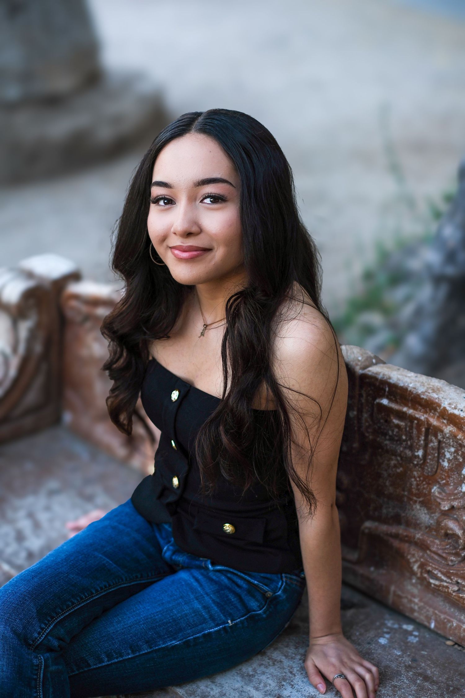 A collection of casual portraits featuring someone in a dark top and denim jeans sitting on a weathered surface.