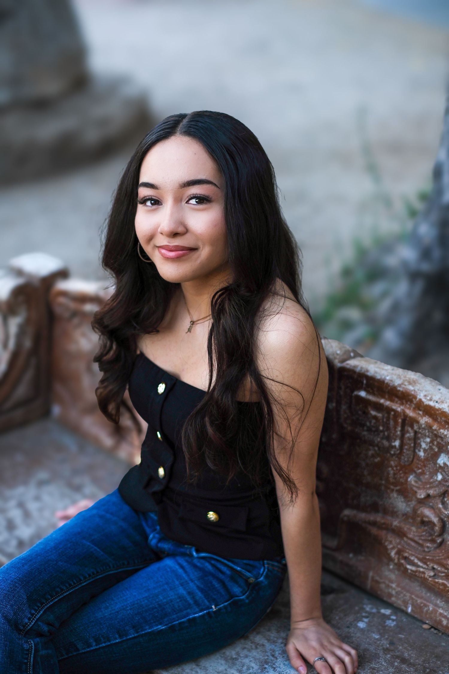 Artistic portrait session on weathered steps showcasing casual style in denim and black.