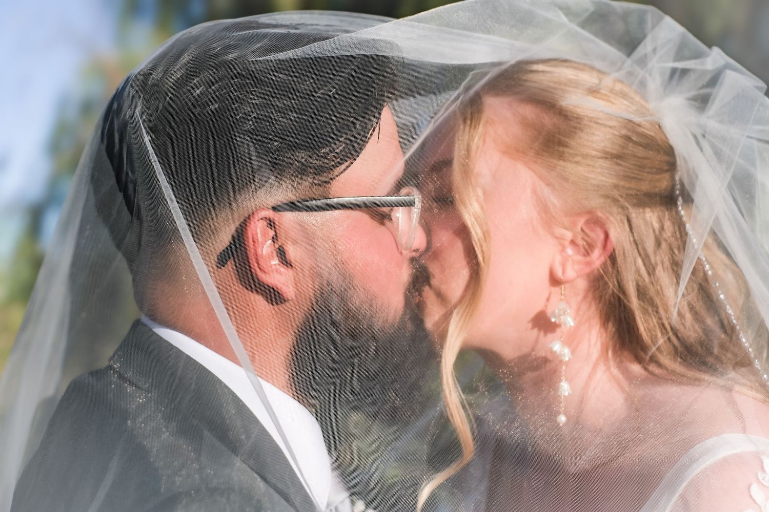 A romantic series of wedding kiss photos captured outdoors in natural lighting.
