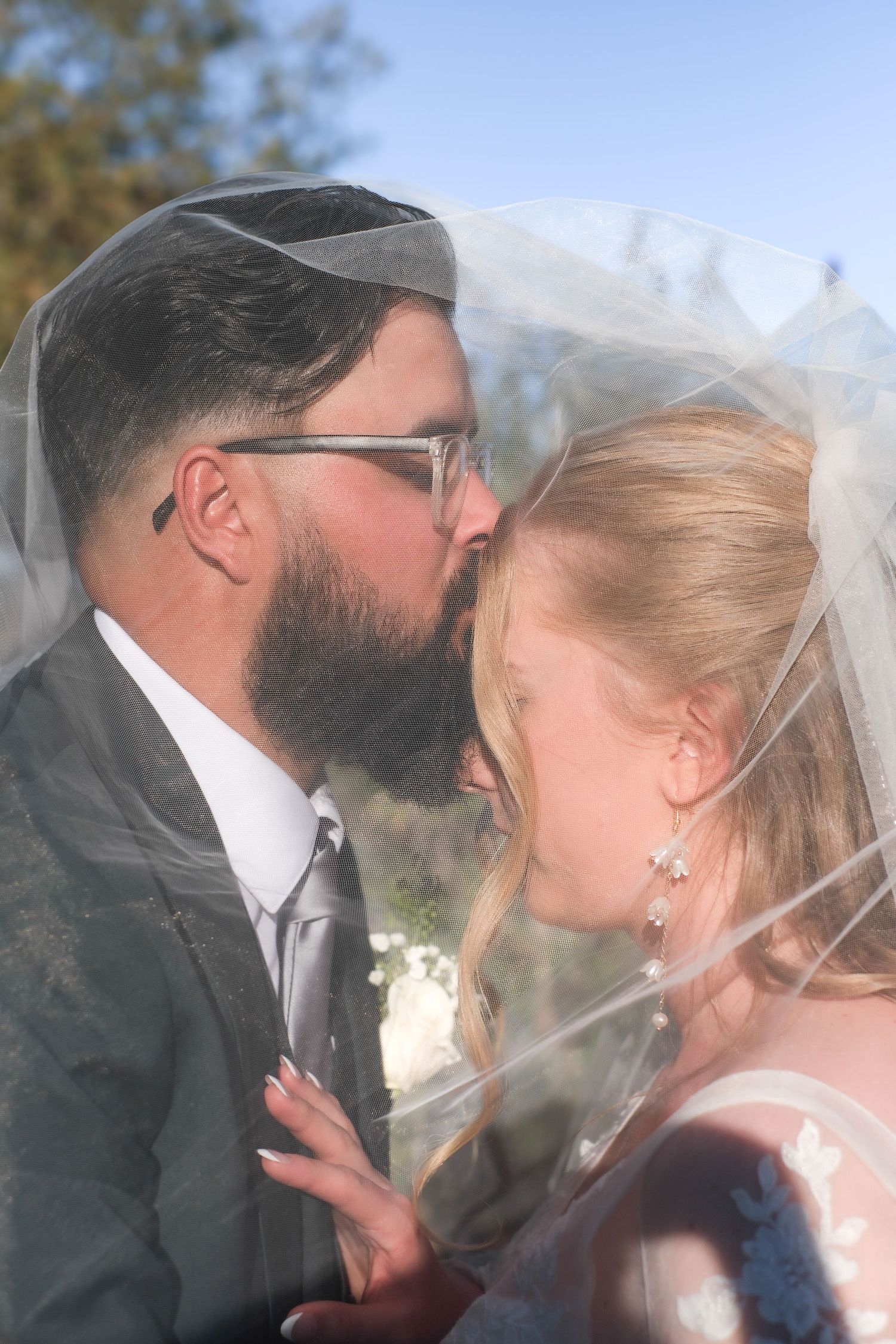 A series of romantic wedding kiss photos showing tender moments through a bridal veil.