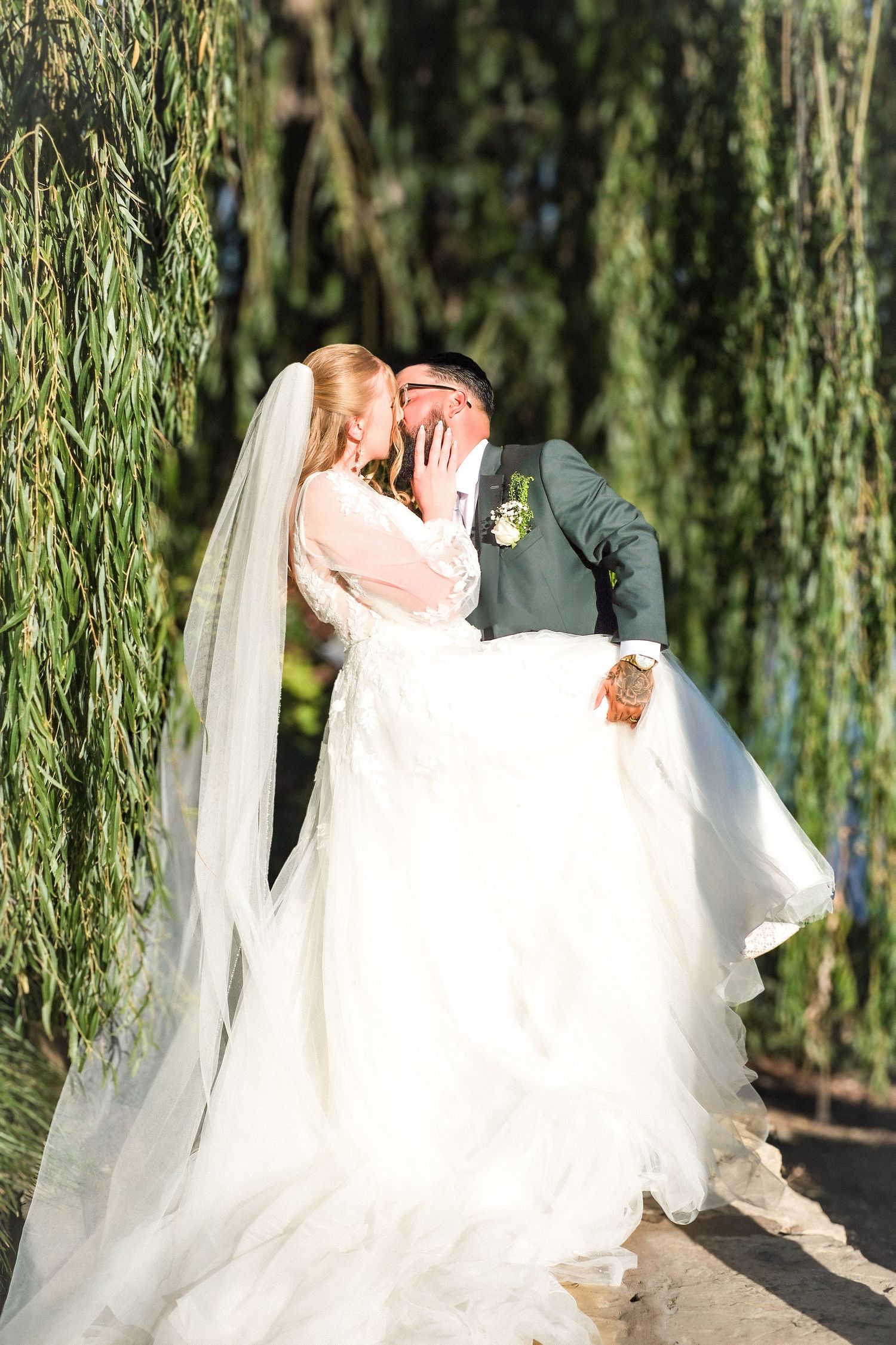 A romantic wedding photo sequence showing a couple kissing under a weeping willow tree with a flowing white dress and veil.