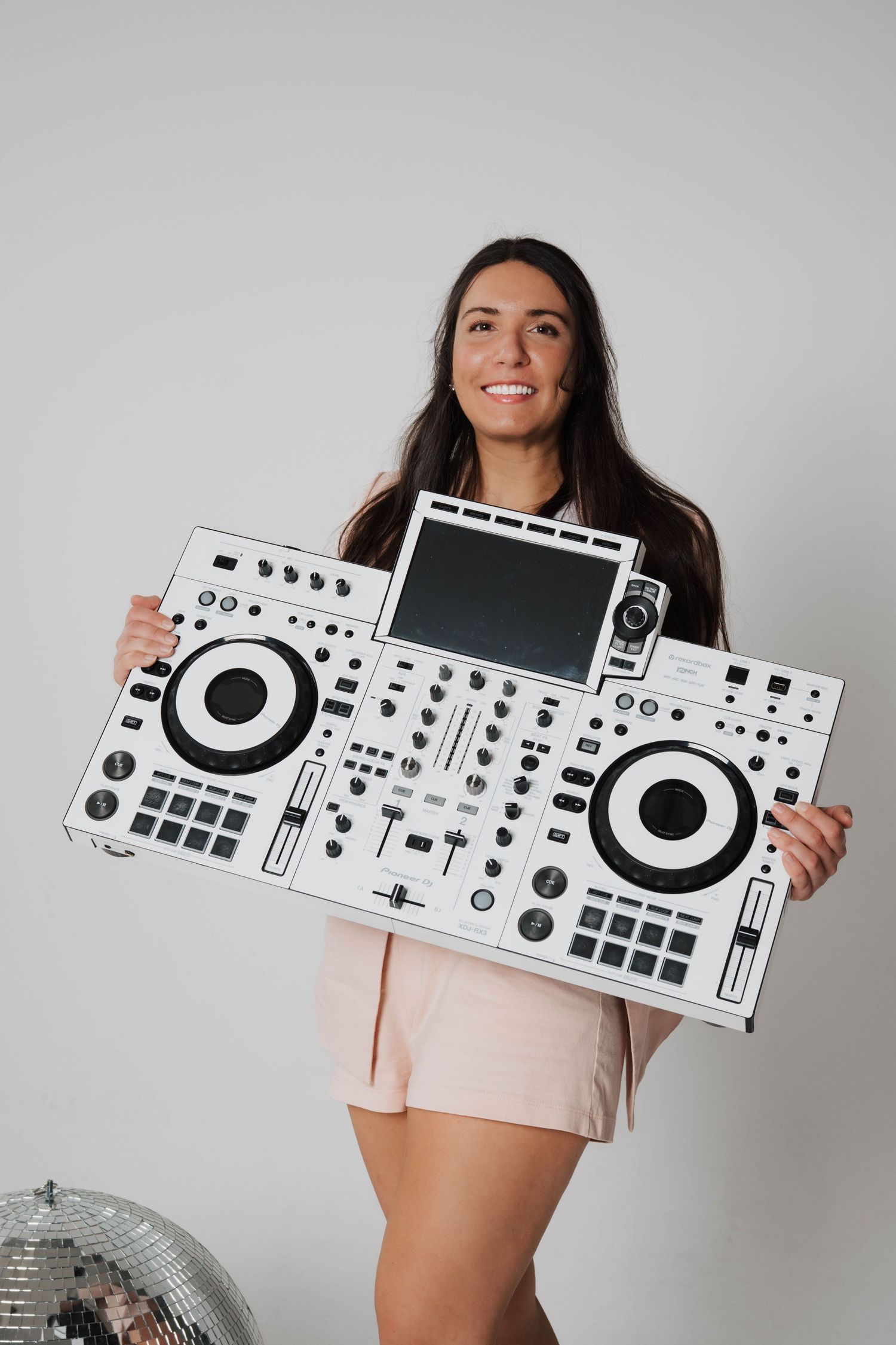 Professional white DJ controller equipment displayed against grey studio backdrop.