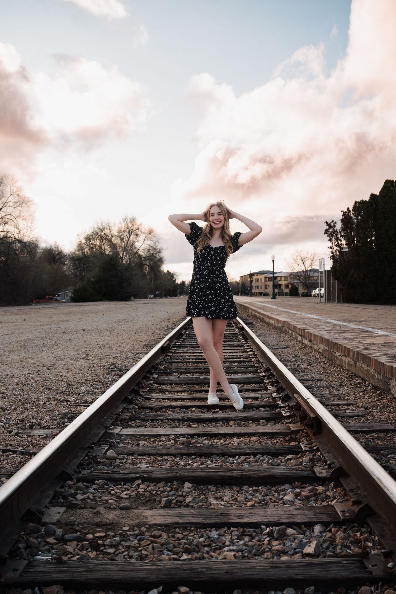 Artistic portrait on railroad tracks during golden hour.
