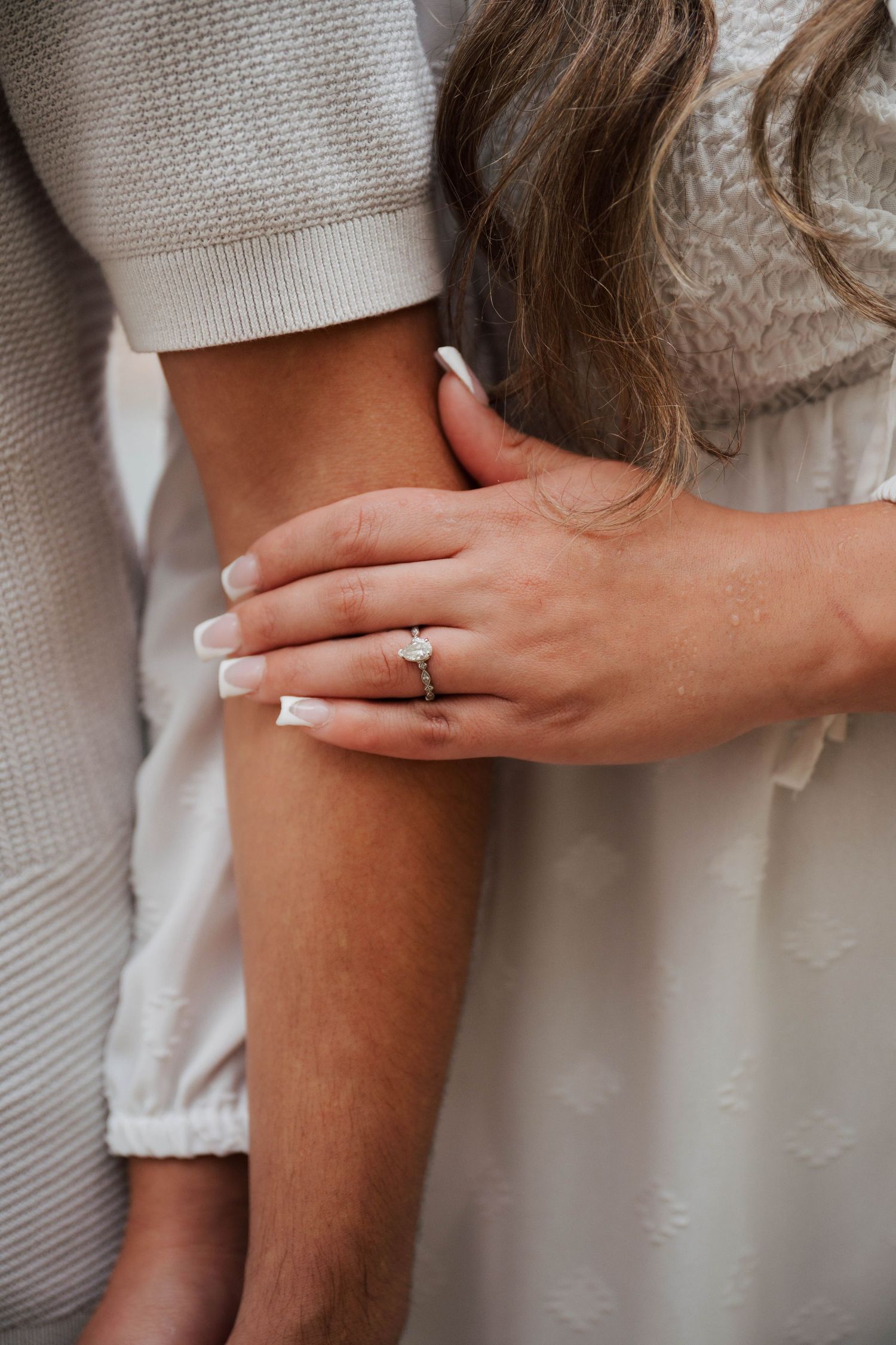 Close-up details of hands and engagement ring in romantic poses.