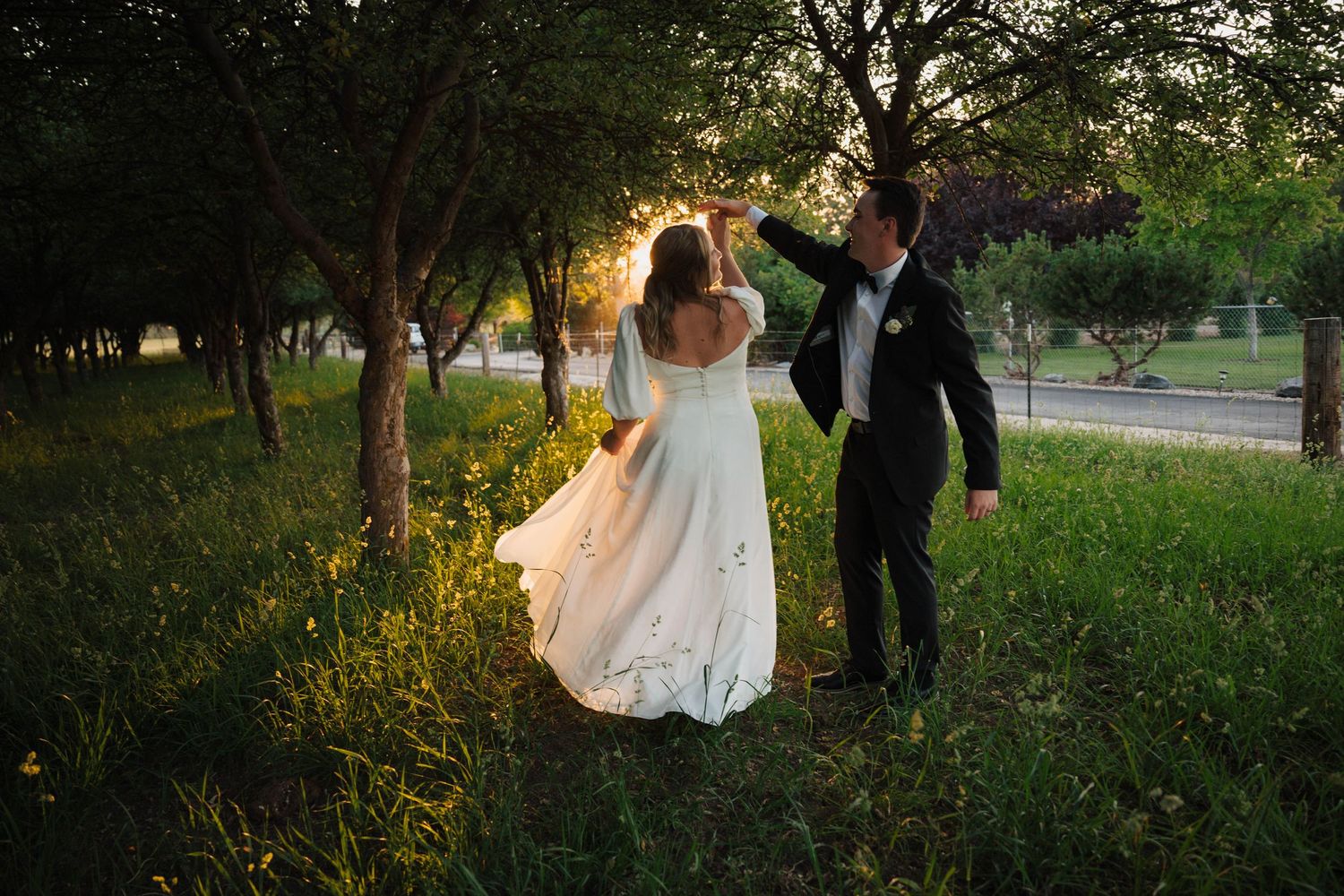 Golden hour wedding photography in a natural outdoor setting with tall grass.