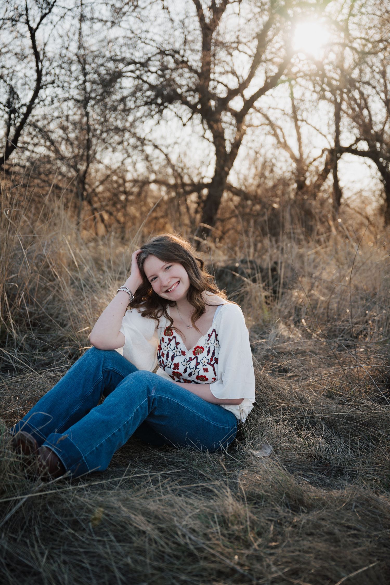 Casual outdoor portrait session in tall grass during golden hour.