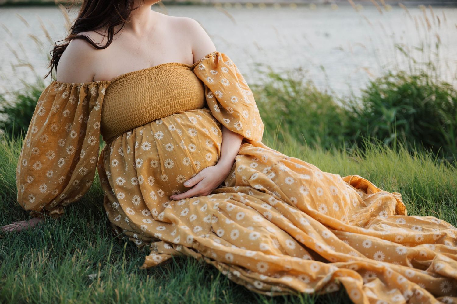 Close-up shots of yellow floral dress flowing in wind against natural backdrop.