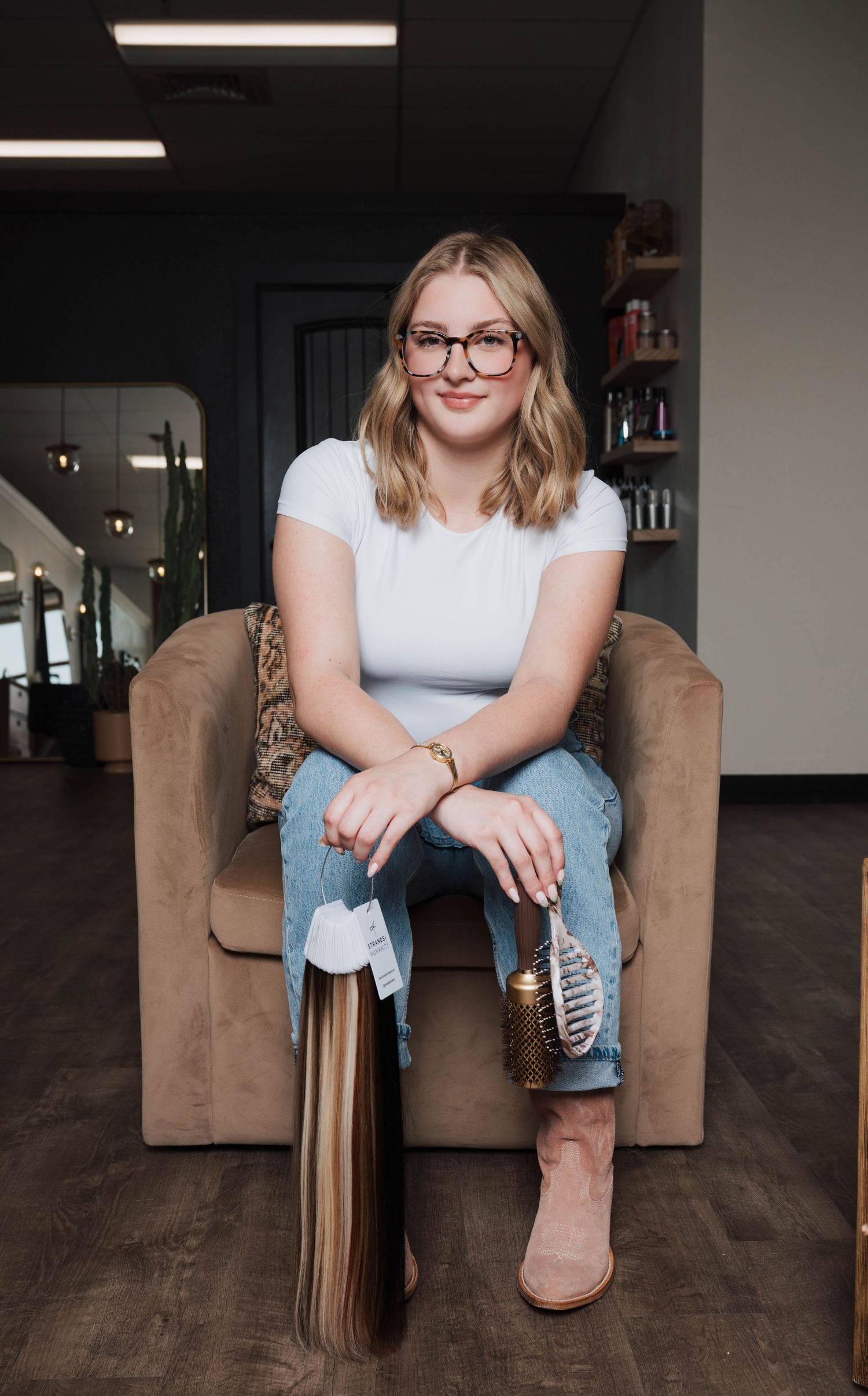 Relaxed portrait session on brown couch wearing casual denim and white top.