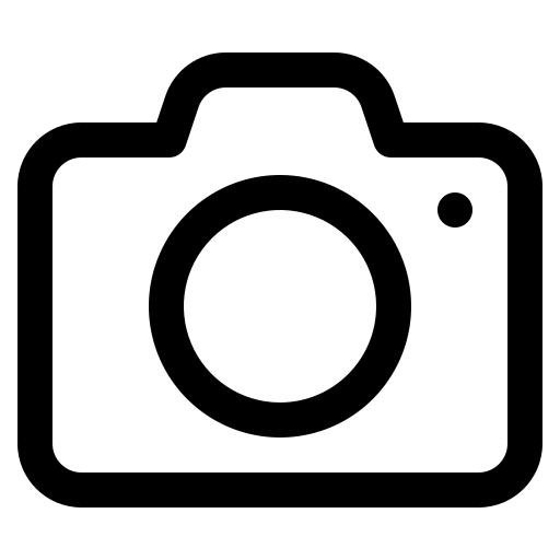 Black and white camera icon with a circular lens, viewfinder bump, and small dot, representing photography or photo upload.