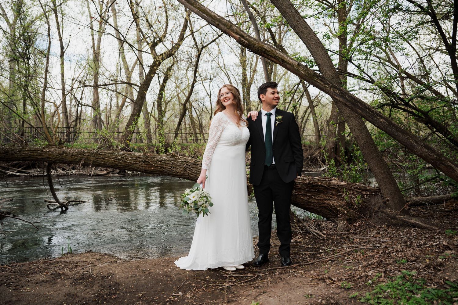 Scenic woodland wedding photos taken along a natural stream bank.